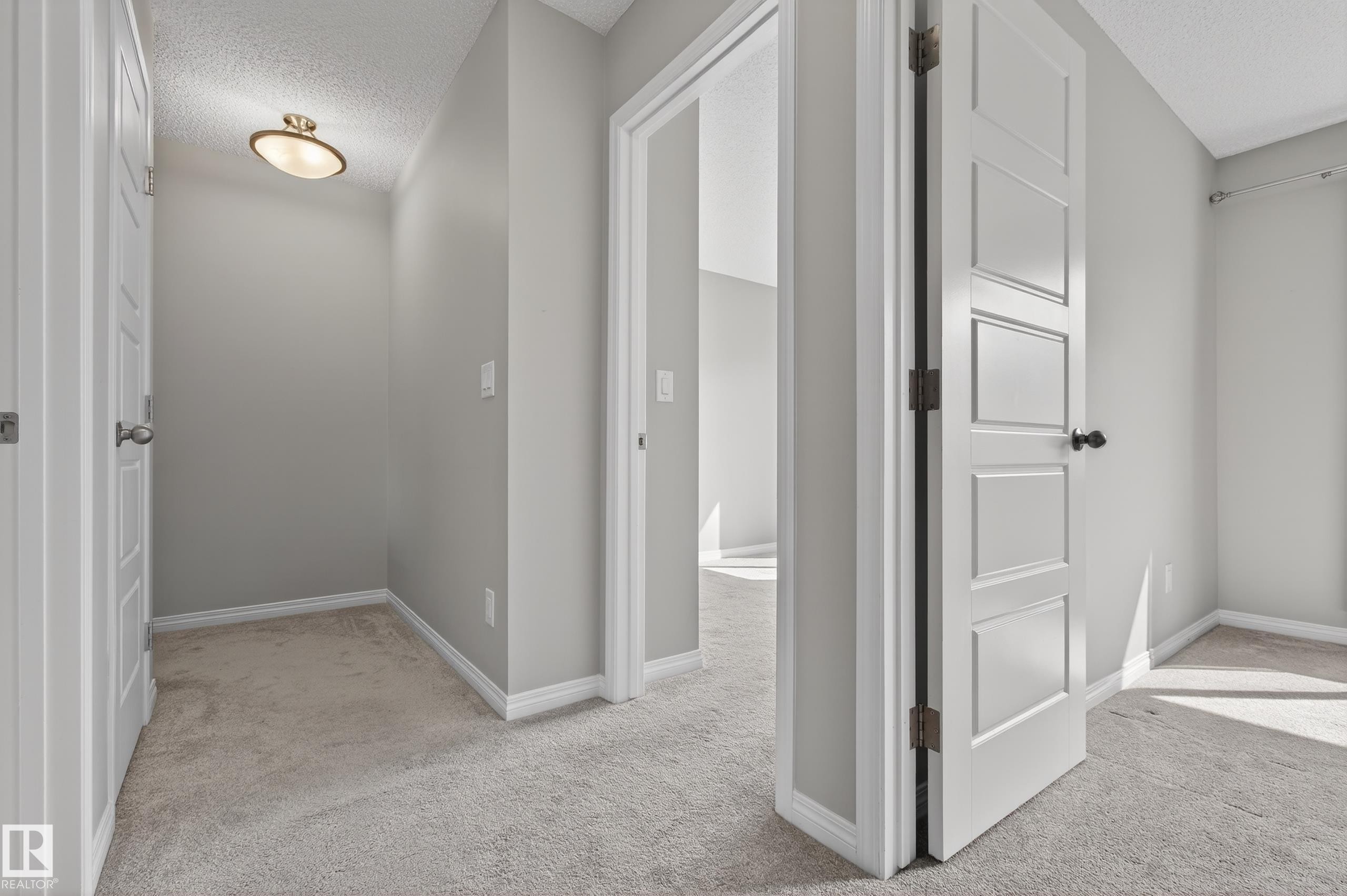 Interior hallway featuring light gray walls, white trim, and light gray carpeting - 15 2072 Wonnacott Way, Edmonton, AB - Indoor Photo Showing Other Room