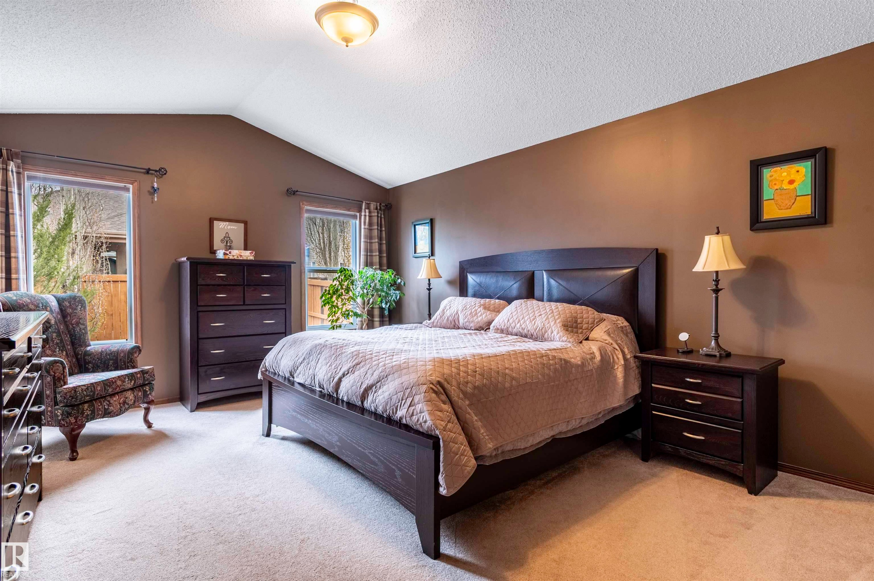 Vaulted ceiling bedroom featuring carpeting, two windows with exterior views, and neutral wall tones - 19 Newton Place, St. Albert, AB - Indoor Photo Showing Bedroom