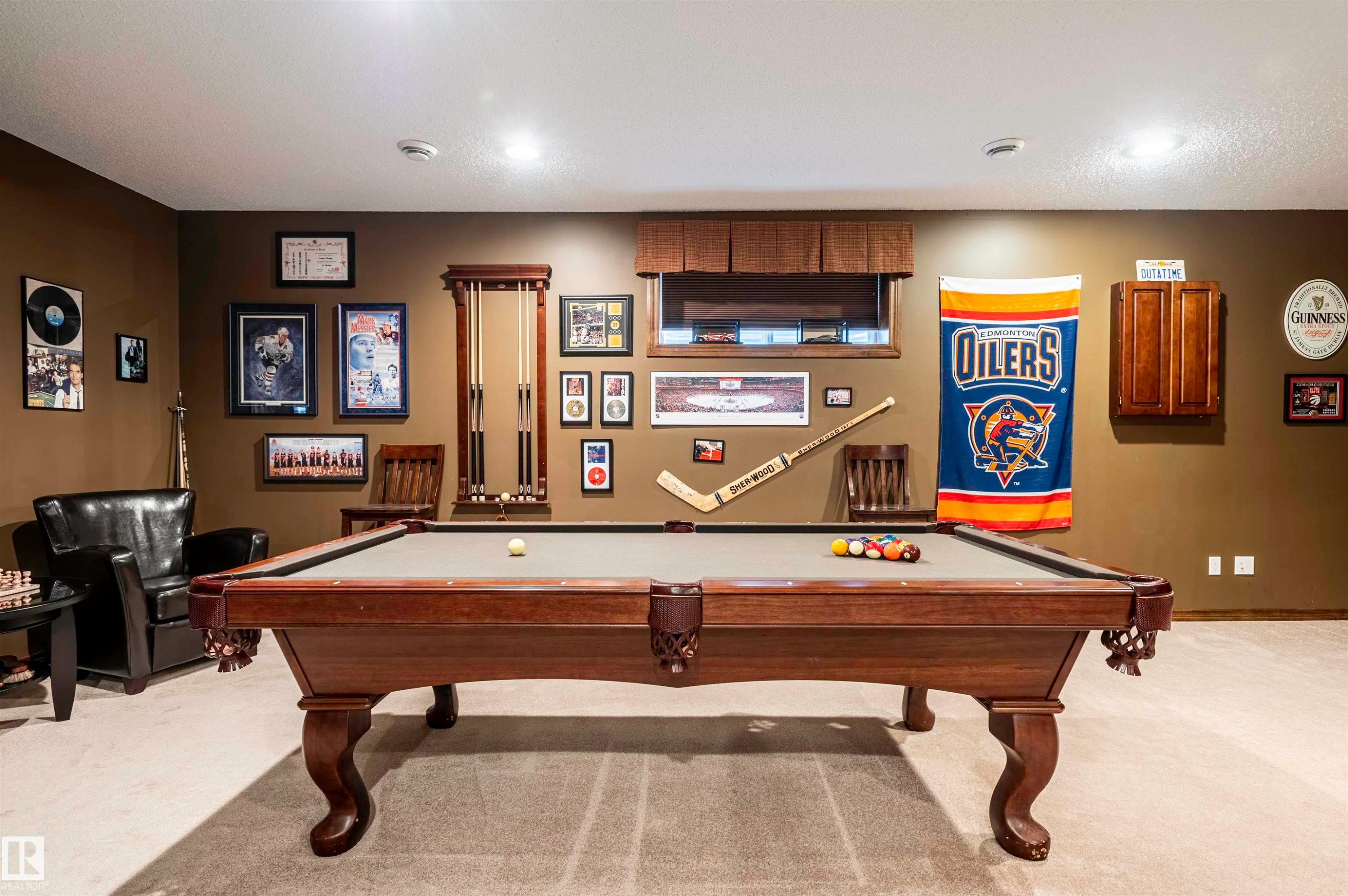 Recreation room featuring a pool table with ornate wood-finish legs, neutral-toned carpet flooring, recessed lighting, and a built-in wood-finish wall cabinet - 19 Newton Place, St. Albert, AB - Indoor Photo Showing Other Room
