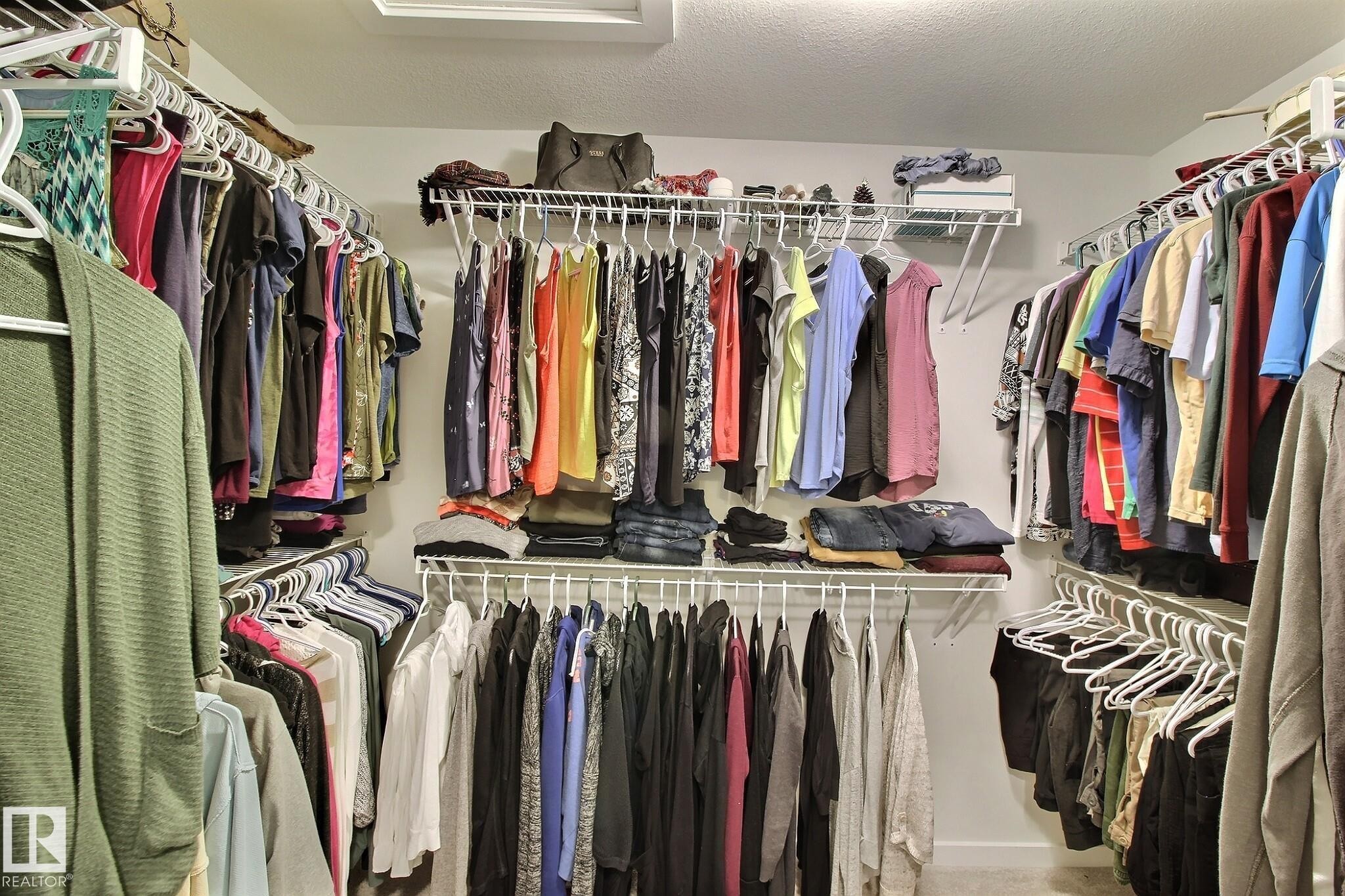 Walk-in closet featuring white wire shelving and multiple hanging rods for organization - 121 Stiles Bend, Leduc, AB - Indoor With Storage
