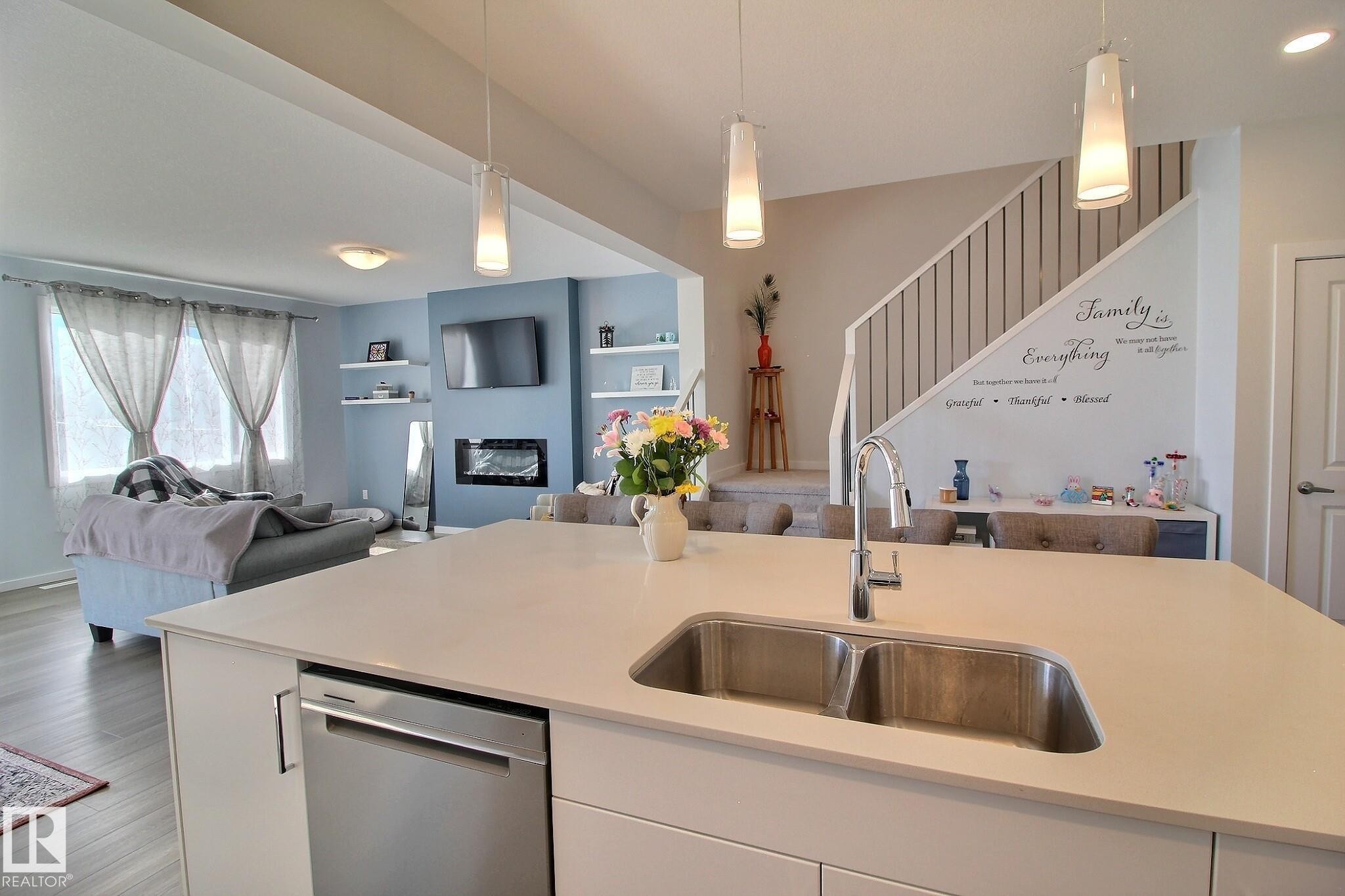 Kitchen island featuring a double basin stainless steel sink with a gooseneck faucet - 121 Stiles Bend, Leduc, AB - Indoor Photo Showing Kitchen With Double Sink