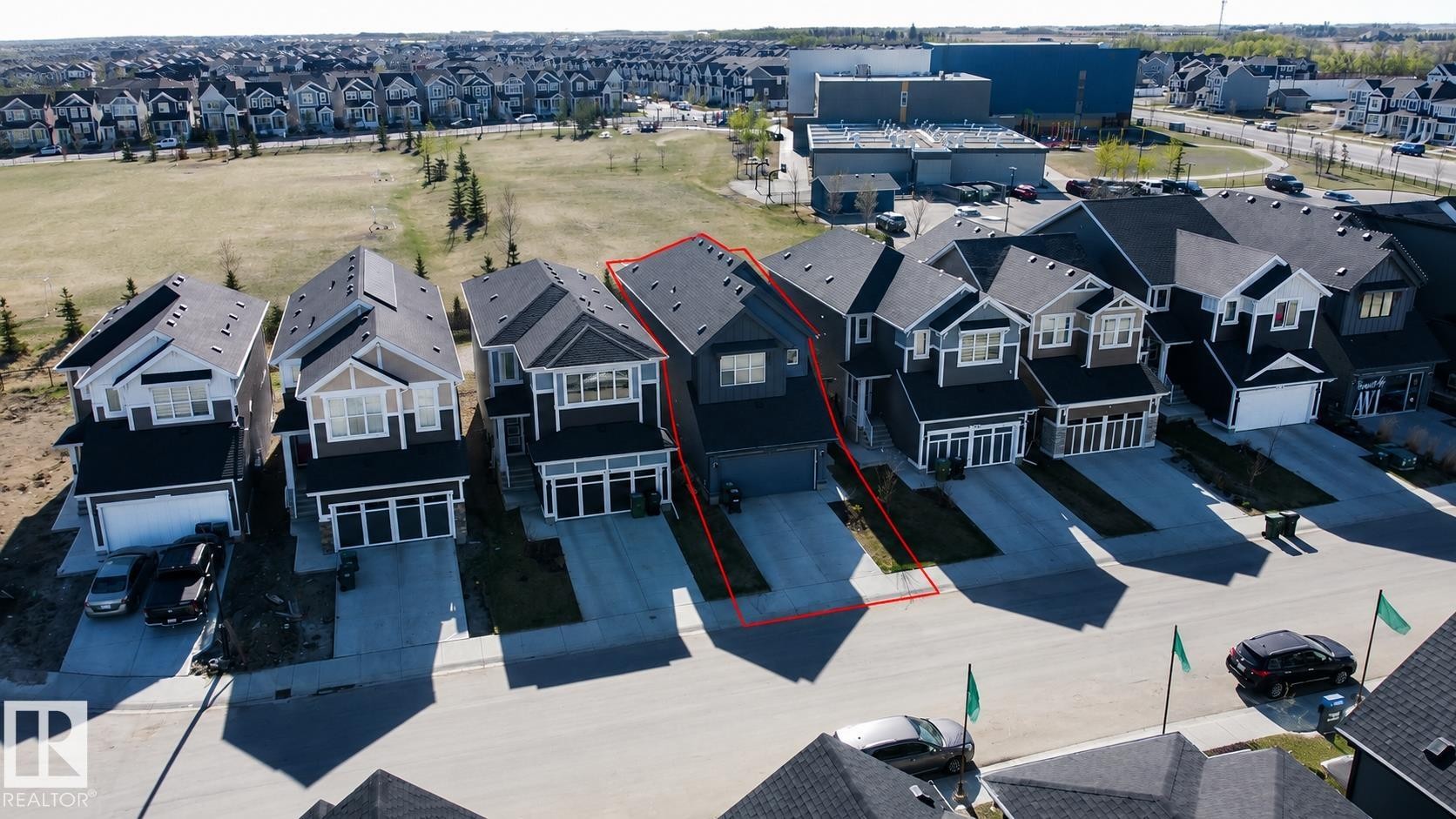 Modern two-story residence featuring a dark gray facade with white trim and a contrasting light gray garage door - 121 Stiles Bend, Leduc, AB - Outdoor