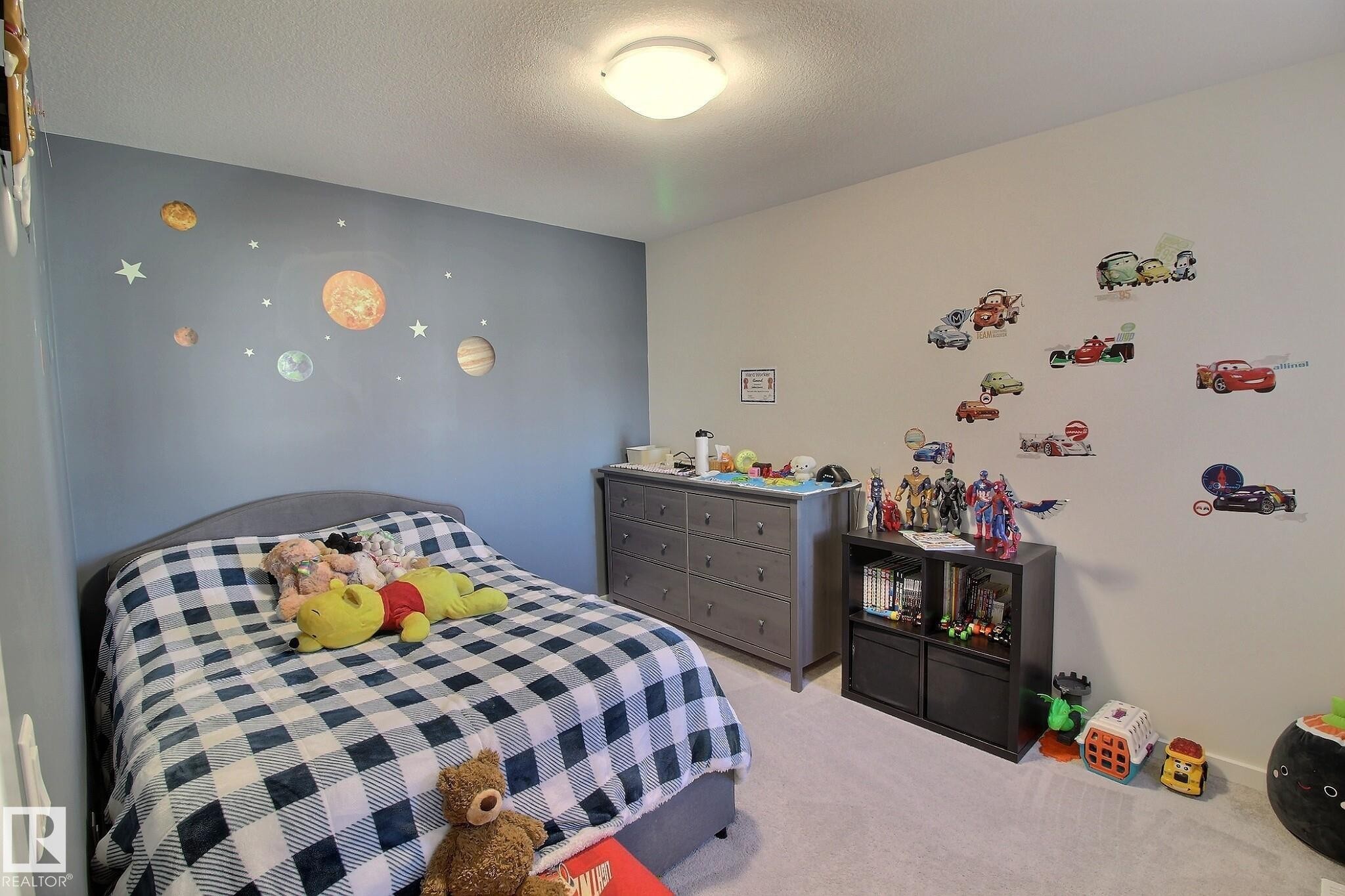 Soft gray carpeting spans the floor, complemented by a light gray accent wall and a neutral white wall - 121 Stiles Bend, Leduc, AB - Indoor Photo Showing Bedroom