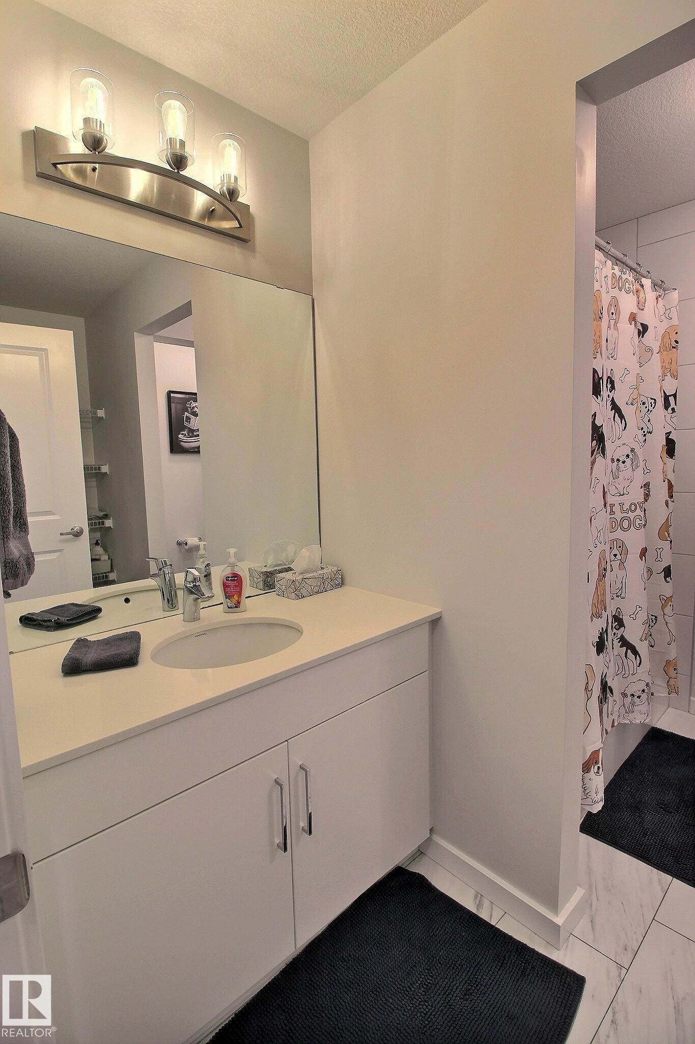 Bathroom vanity featuring a light countertop, recessed sink, and brushed nickel fixtures - 121 Stiles Bend, Leduc, AB - Indoor Photo Showing Bathroom