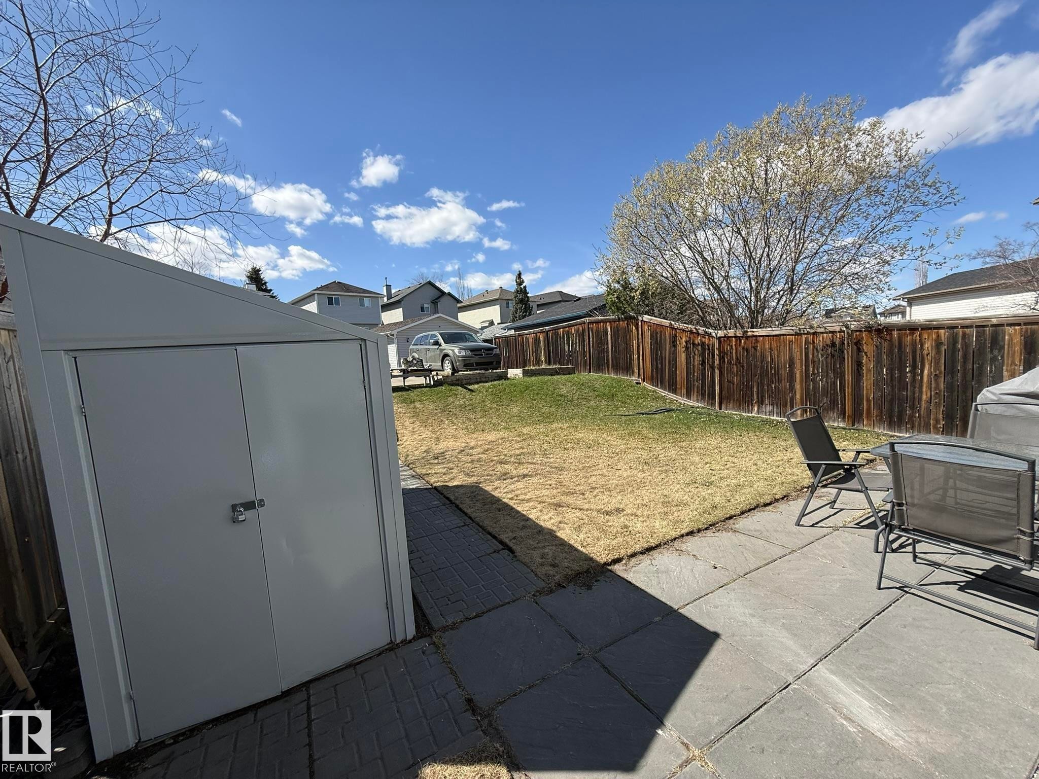 Expansive backyard featuring a combination of established lawn and patio pavers - 645 Windross Crescent, Edmonton, AB