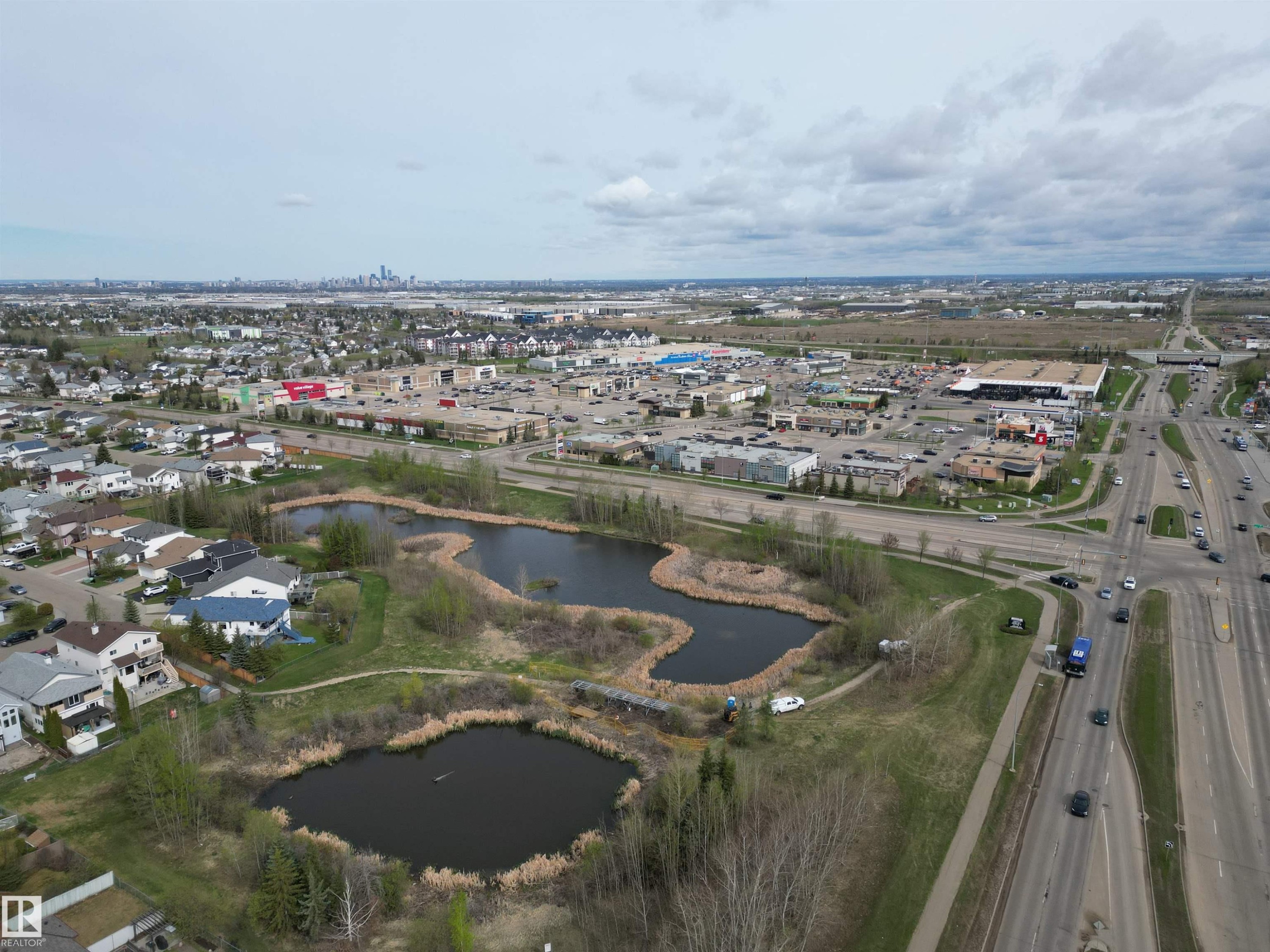 Aerial perspective showcasing residential properties, multiple bodies of water, and surrounding commercial areas - 645 Windross Crescent, Edmonton, AB