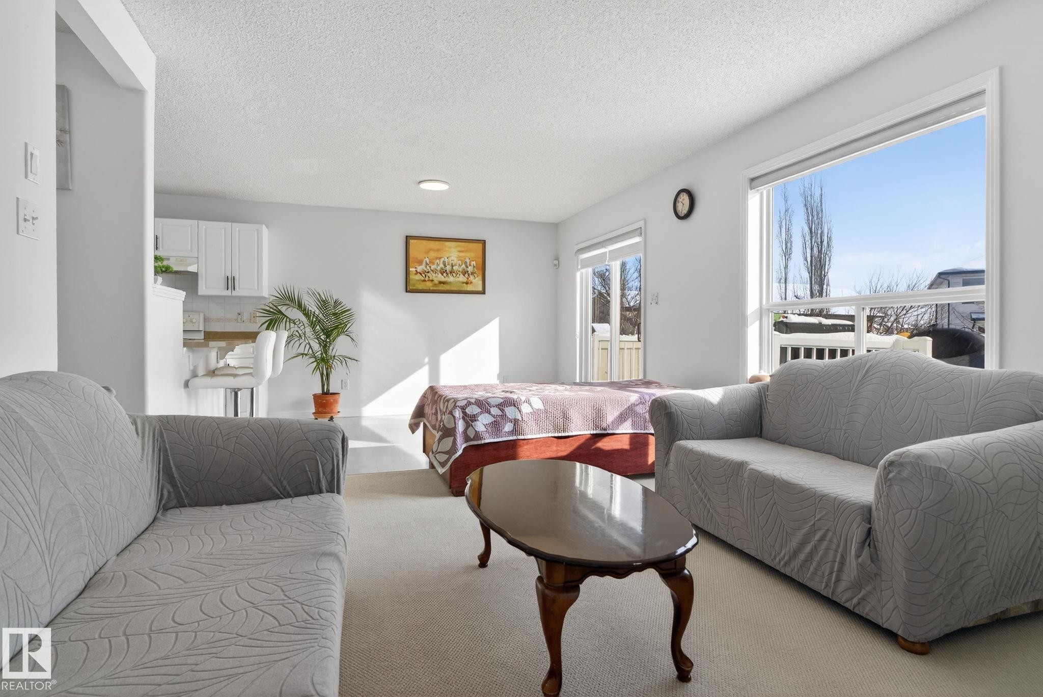 Open-concept living area with light-toned wall paint and carpet flooring - 421 84 Street, Edmonton, AB - Indoor Photo Showing Living Room