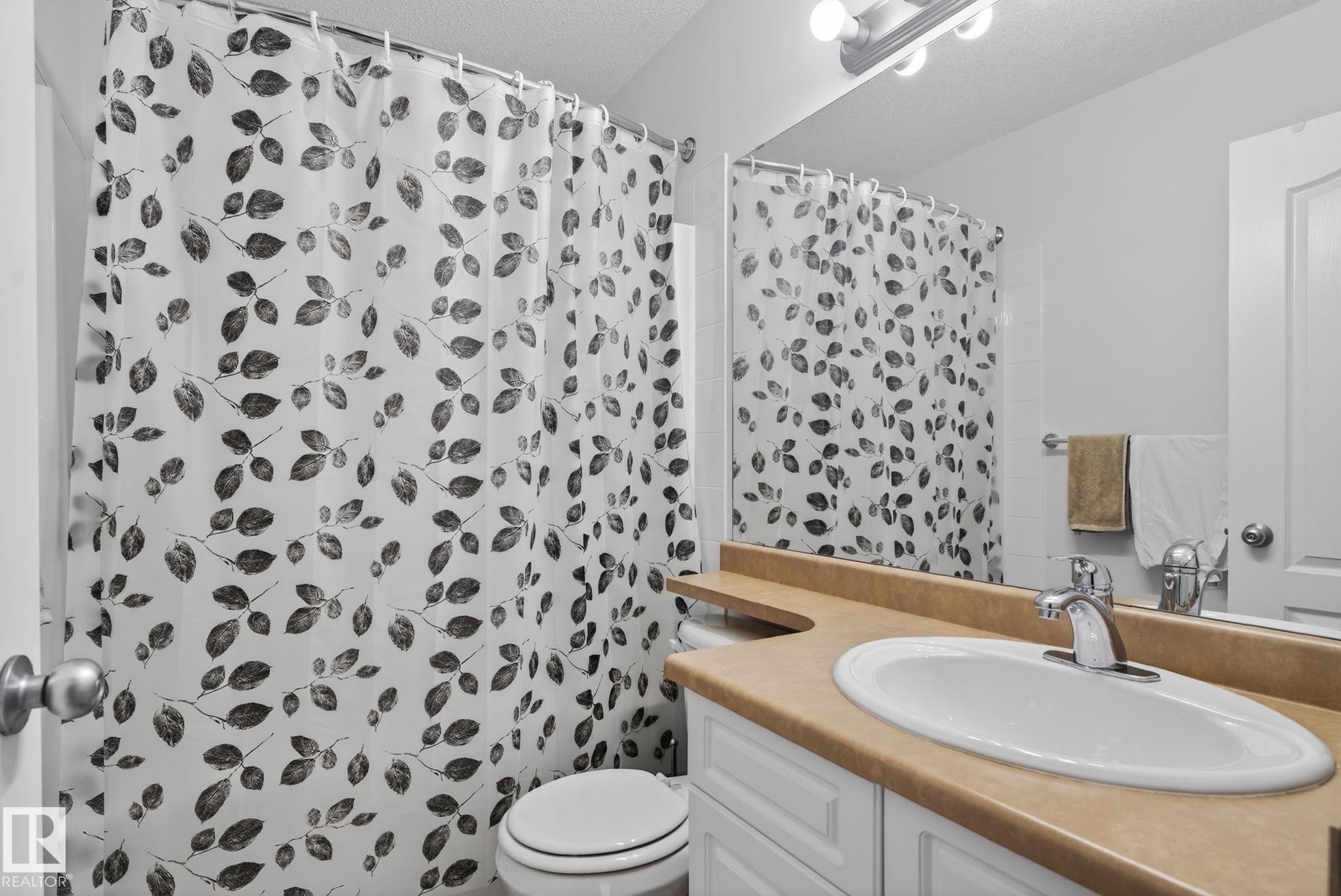 Bathroom featuring a built-in vanity with a single basin sink and a large wall mirror - 421 84 Street, Edmonton, AB - Indoor Photo Showing Bathroom