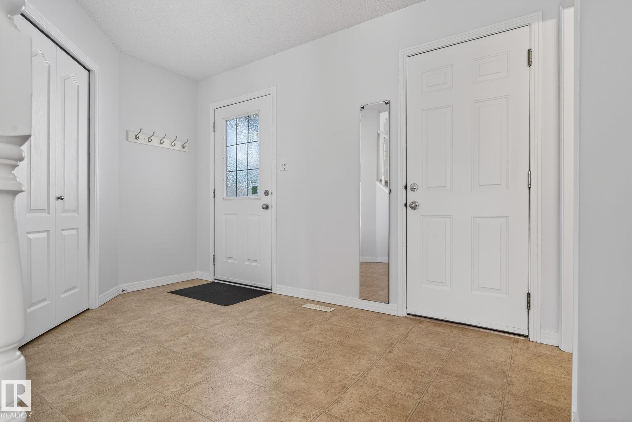 Entryway featuring durable tile flooring, a paneled entry door with frosted glass, and a second paneled door - 421 84 Street, Edmonton, AB - Indoor Photo Showing Other Room