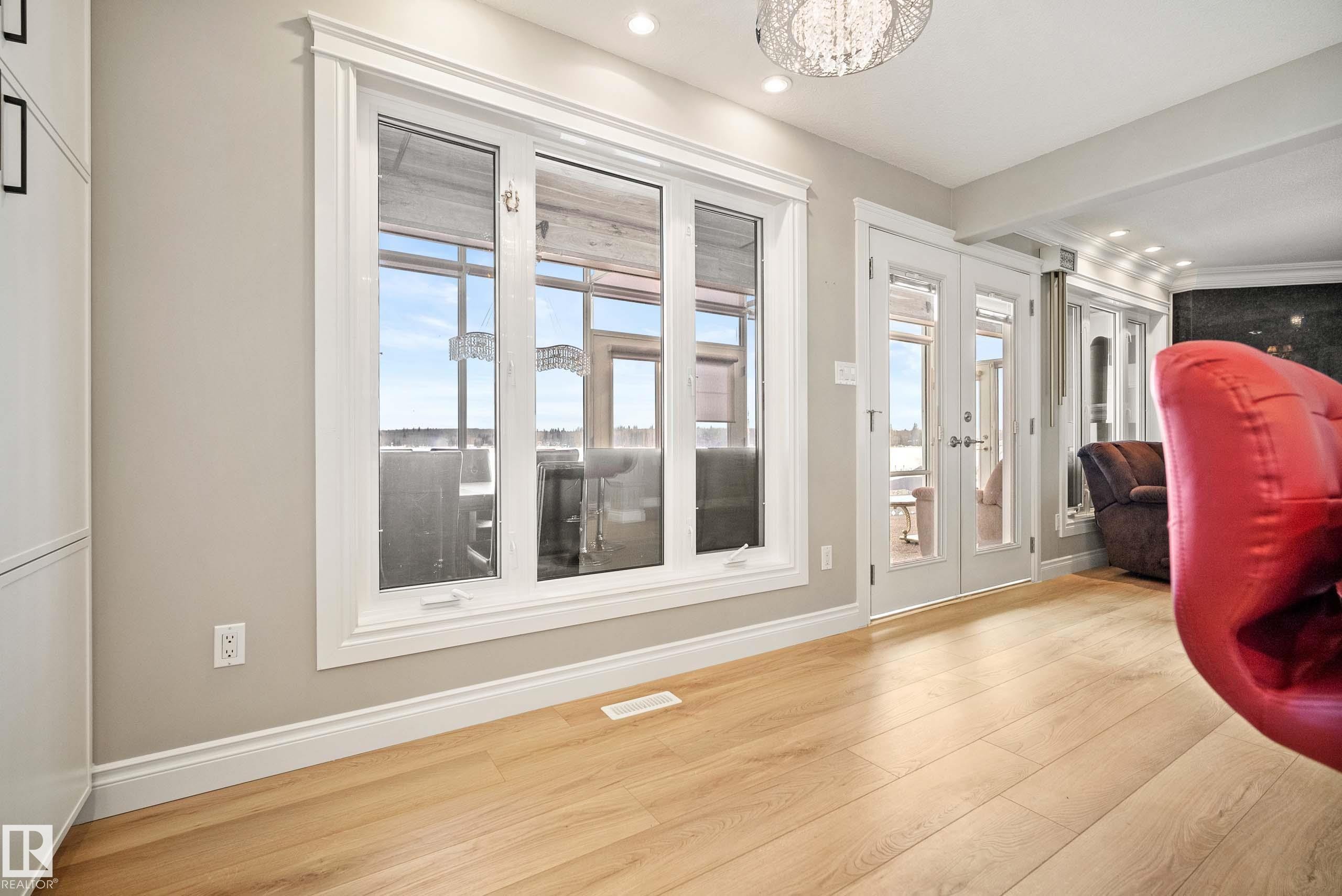 Light-toned wood-finish flooring complements the white trim and neutral wall color - 104 Bayview Drive, Rural Parkland County, AB - Indoor Photo Showing Other Room