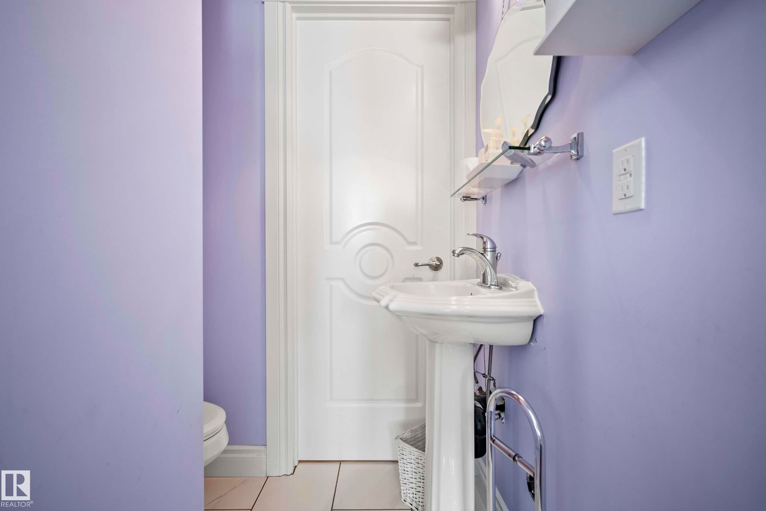 Pedestal sink with chrome faucet, complemented by a wall-mounted mirror and glass shelf - 104 Bayview Drive, Rural Parkland County, AB - Indoor Photo Showing Bathroom