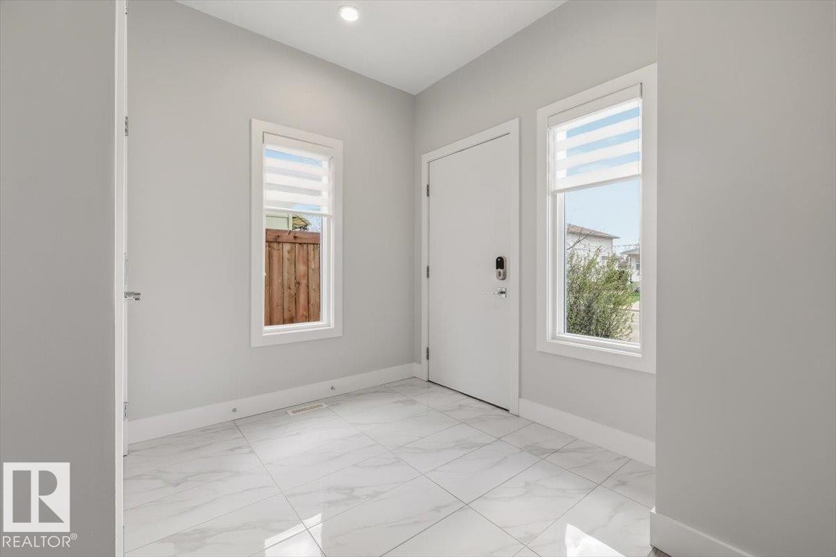Entryway featuring white marble-look tile flooring, light gray wall paint, and white trim - 9933 79 Street, Edmonton, AB - Indoor Photo Showing Other Room