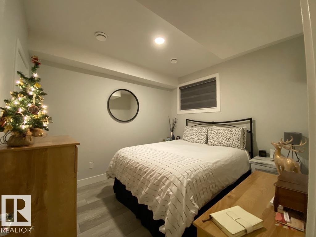 Bedroom featuring light gray walls, recessed lighting, and wood-finish flooring - 9933 79 Street, Edmonton, AB - Indoor Photo Showing Bedroom