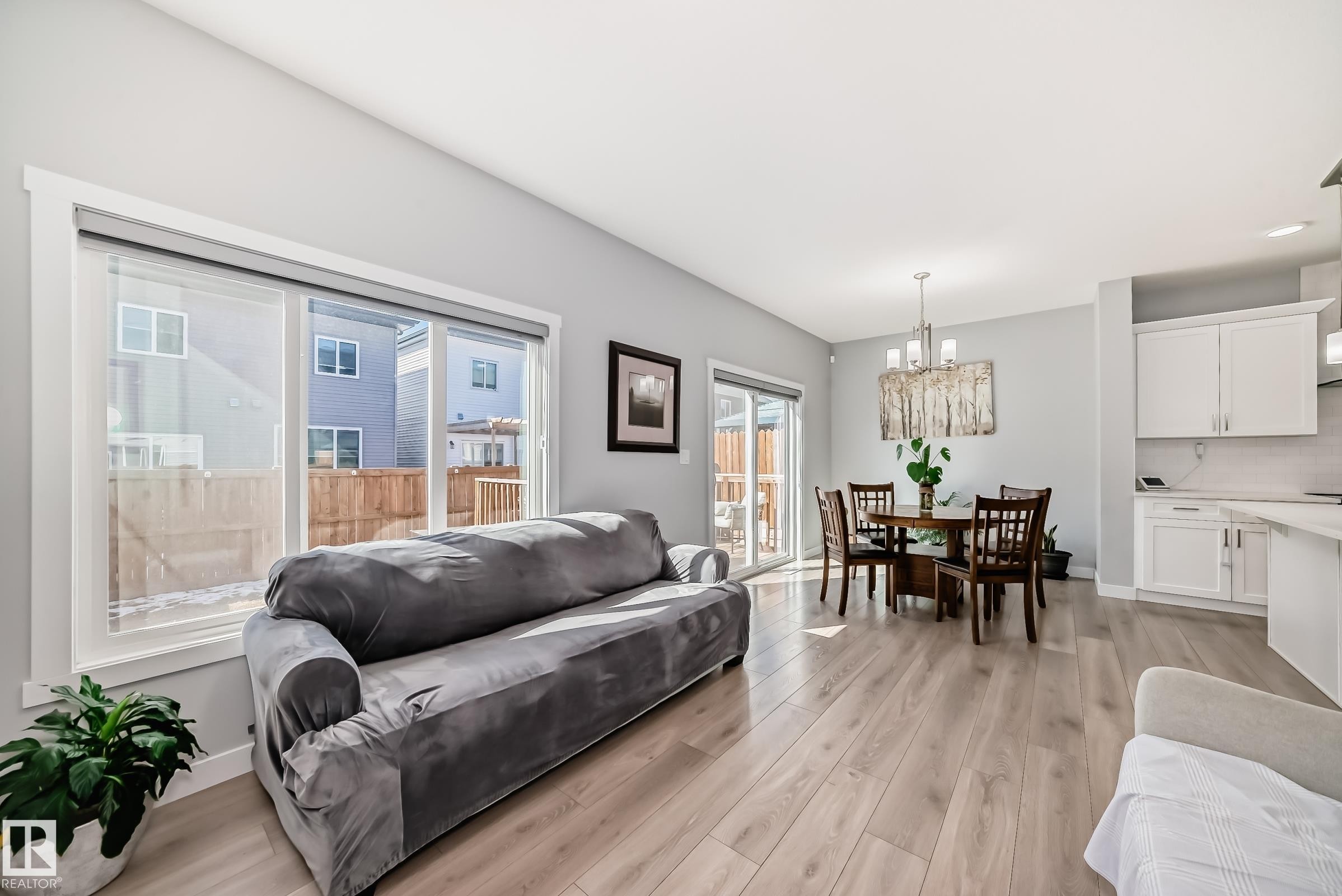 Open-concept living space featuring light wood-finish flooring, a sliding glass door, and recessed lighting - 19635 29 Avenue, Edmonton, AB - Indoor Photo Showing Living Room