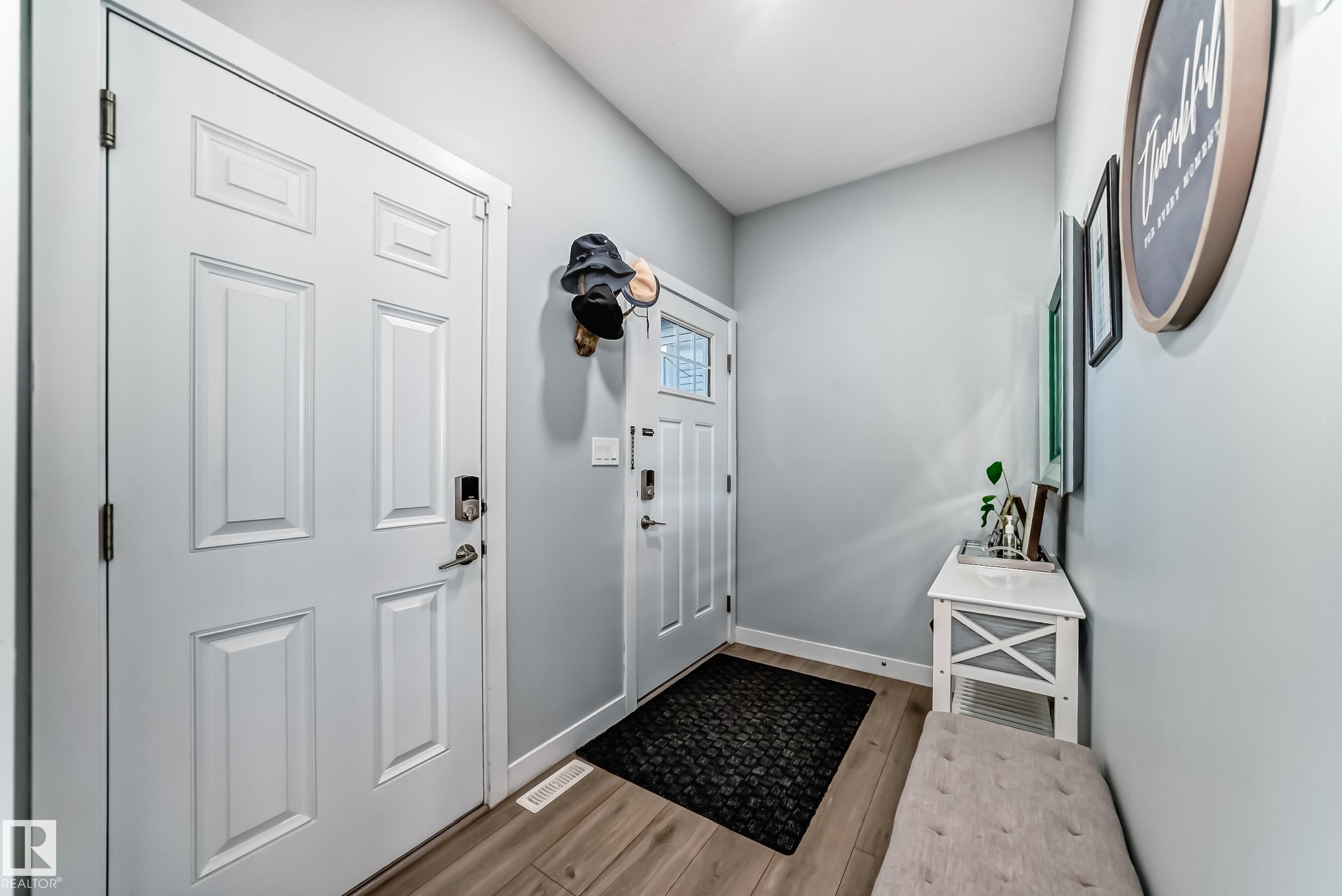 Entryway featuring wood-finish flooring, light grey wall paint, and white trim - 19635 29 Avenue, Edmonton, AB - Indoor Photo Showing Other Room