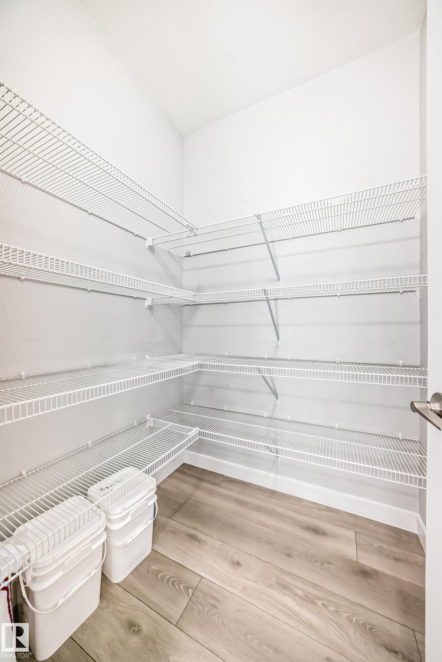 Pantry featuring wrap-around wire shelving and wood-finish flooring - 19635 29 Avenue, Edmonton, AB - Indoor With Storage