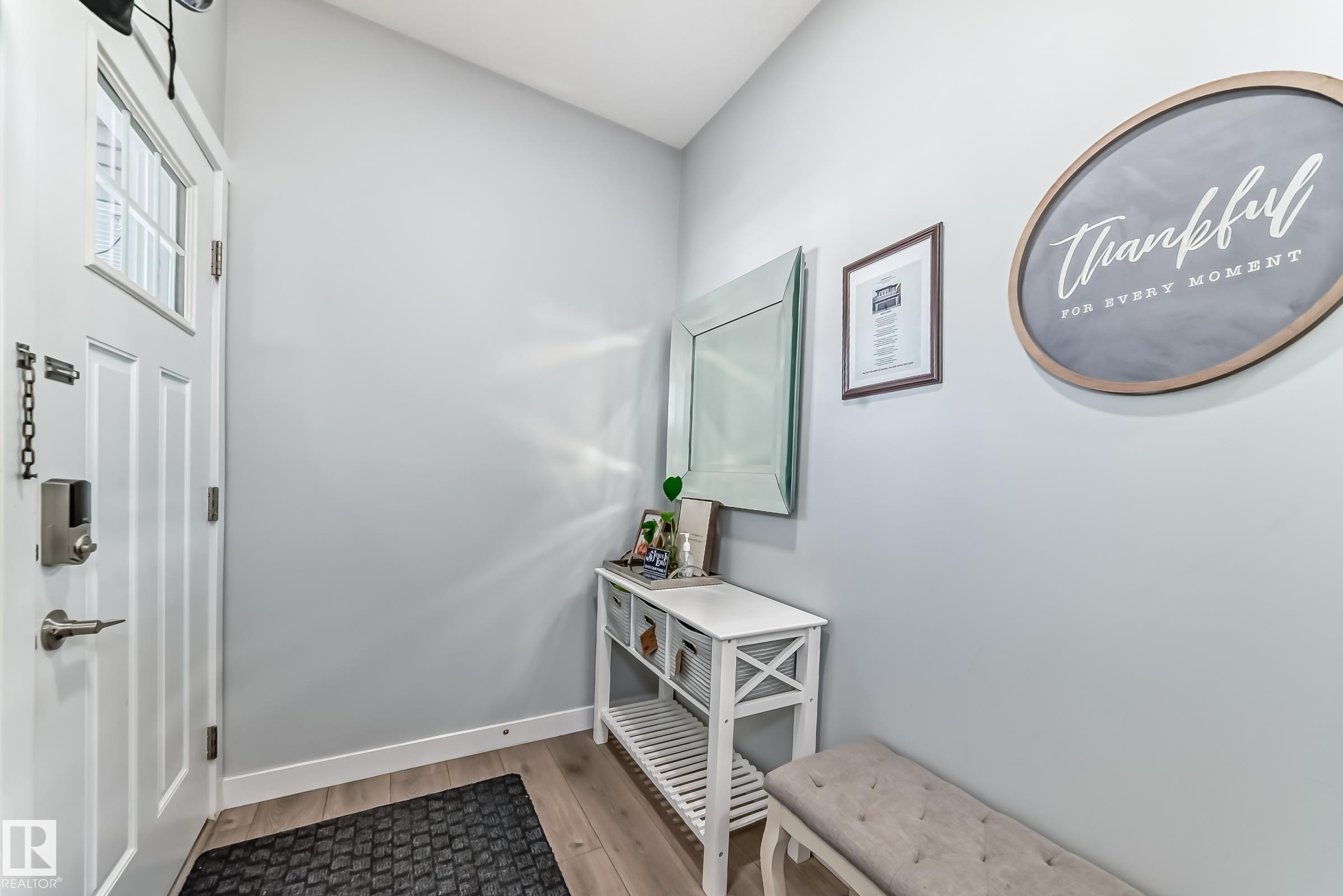 Entryway featuring a white paneled door with glass inserts, wood-finish flooring, light gray wall tones, and white baseboards - 19635 29 Avenue, Edmonton, AB - Indoor Photo Showing Other Room
