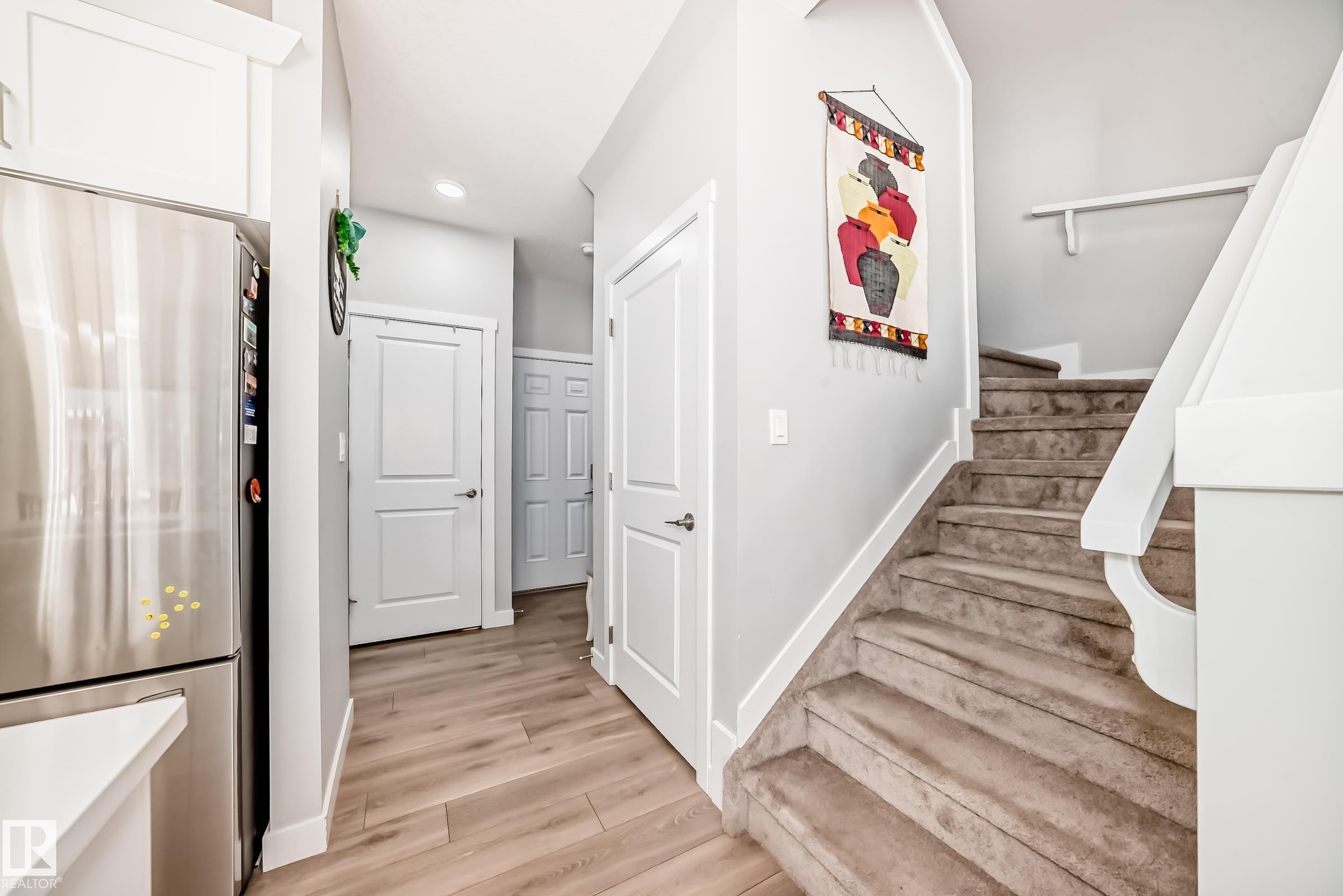 Staircase with carpeted treads and white wood newel post and handrail - 19635 29 Avenue, Edmonton, AB - Indoor Photo Showing Other Room