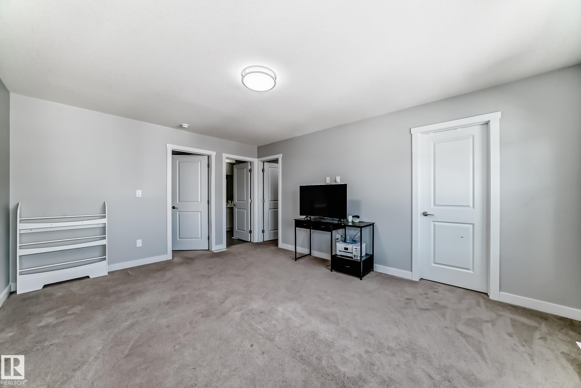Neutral-toned carpet flooring and light gray wall paint create a versatile interior - 19635 29 Avenue, Edmonton, AB - Indoor