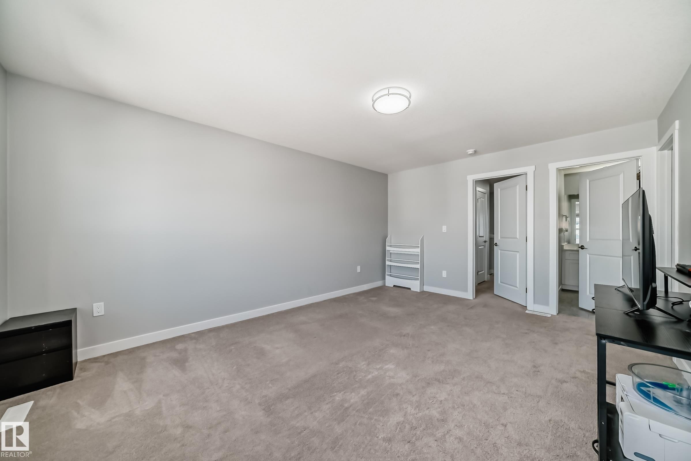 Spacious room featuring neutral carpeting, light gray wall paint, and white trim - 19635 29 Avenue, Edmonton, AB - Indoor Photo Showing Other Room