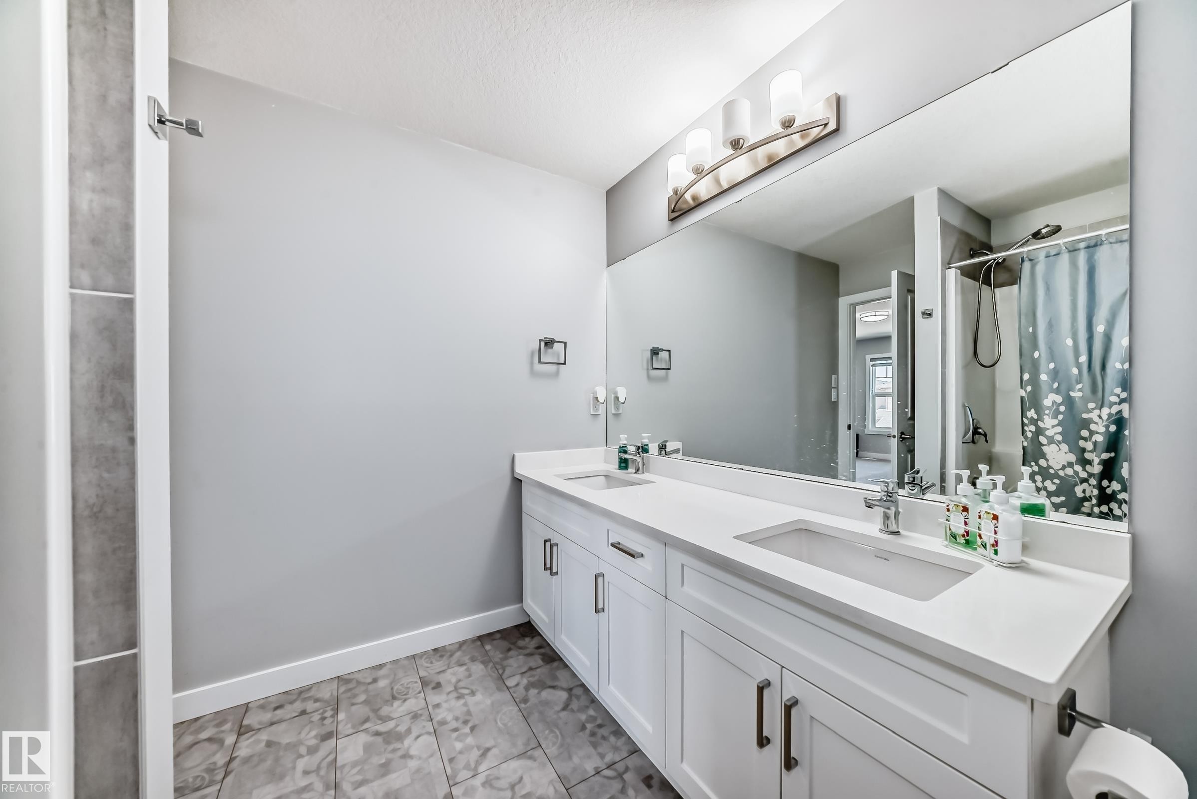 Dual vanity with integrated sinks, white cabinetry, and matte black hardware - 19635 29 Avenue, Edmonton, AB - Indoor Photo Showing Bathroom