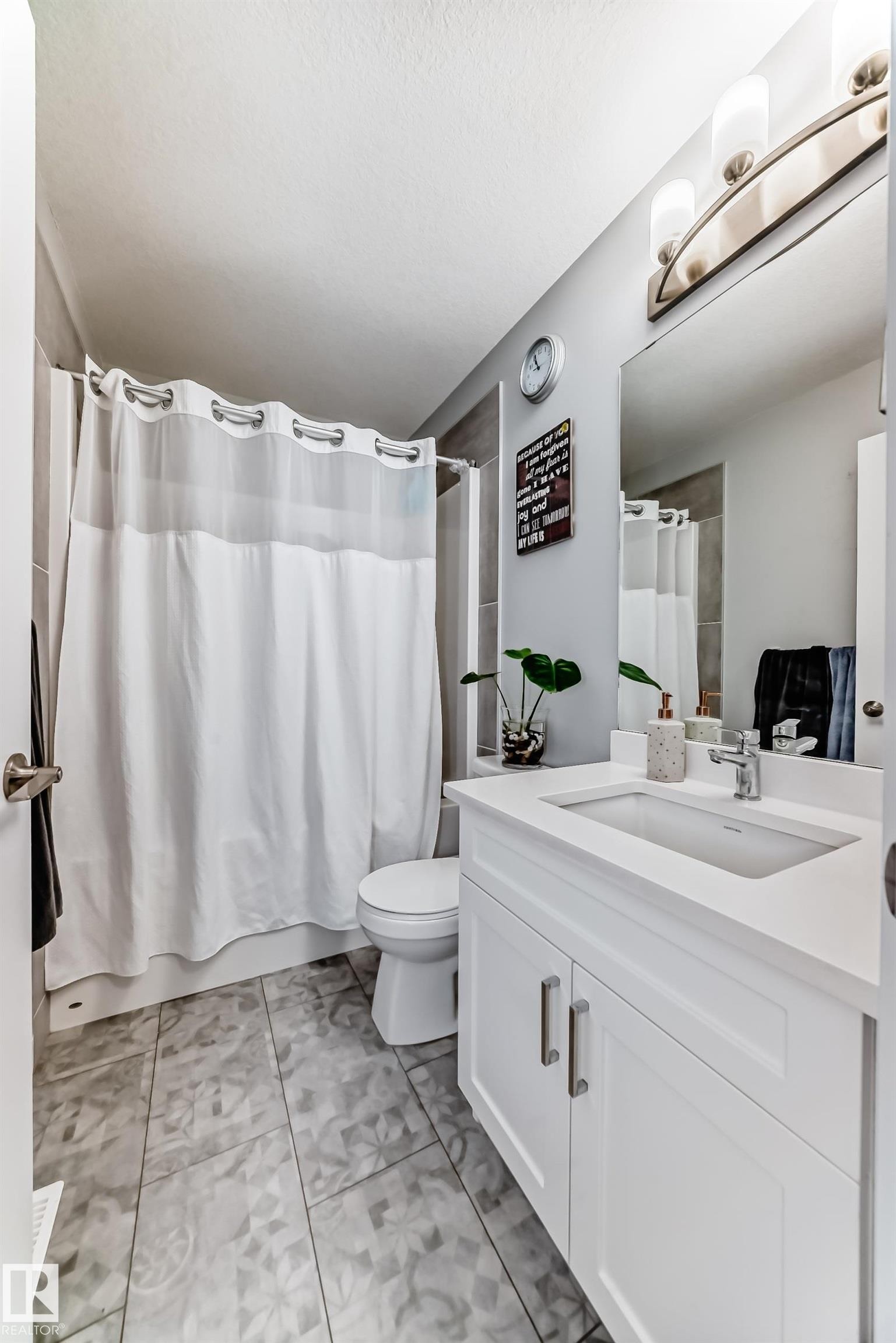 Bathroom featuring a white vanity with an integrated sink, polished chrome faucet, and coordinating cabinet pulls - 19635 29 Avenue, Edmonton, AB - Indoor Photo Showing Bathroom