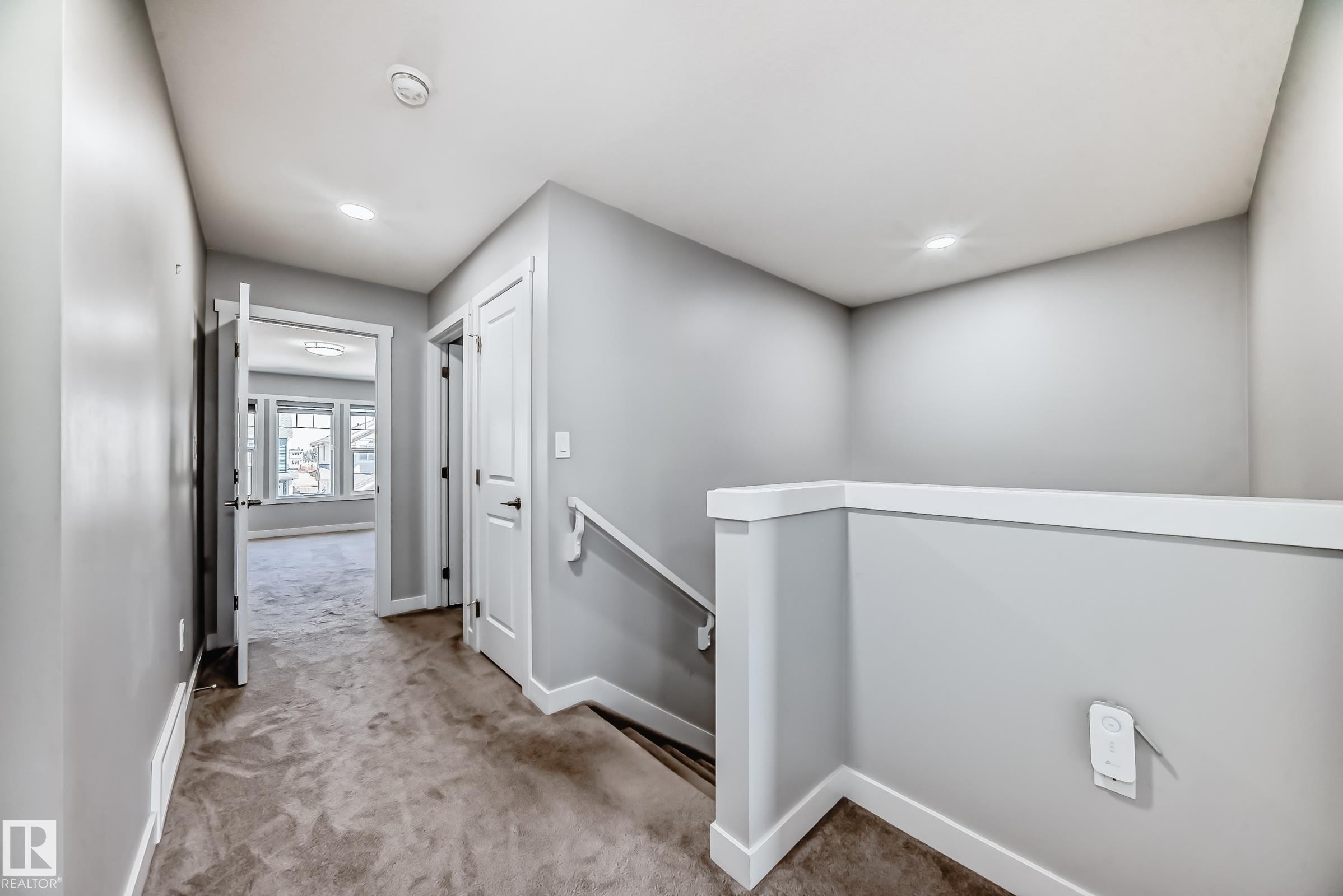 Carpeted hallway featuring light gray walls and white trim - 19635 29 Avenue, Edmonton, AB - Indoor Photo Showing Other Room