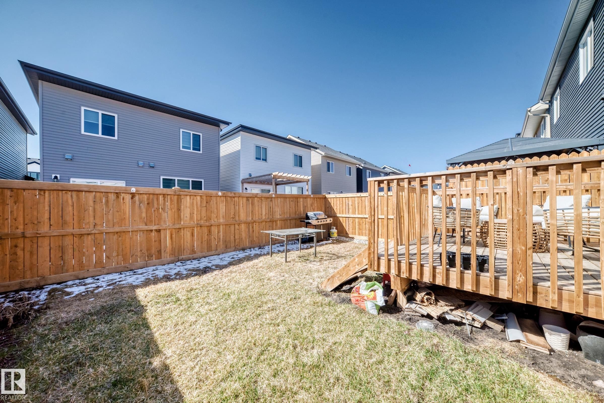 Private backyard featuring a wood deck, wood privacy fence, and a grass lawn - 19635 29 Avenue, Edmonton, AB - Outdoor