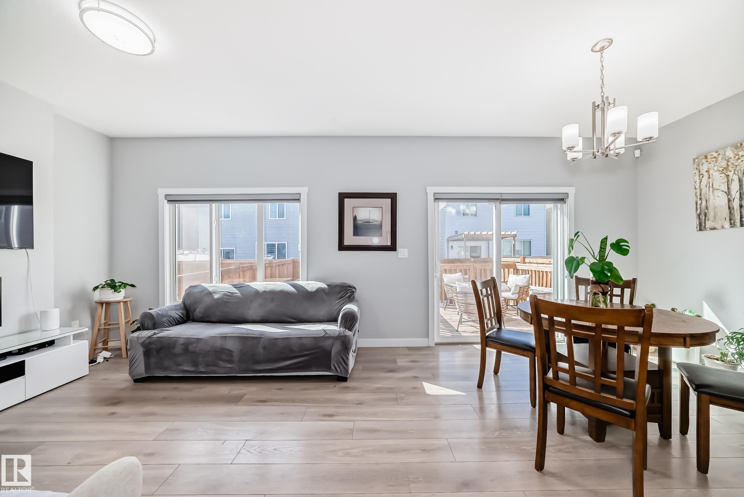 Open-concept living area with light wood-finish flooring, recessed ceiling lighting, and a modern chandelier - 19635 29 Avenue, Edmonton, AB - Indoor