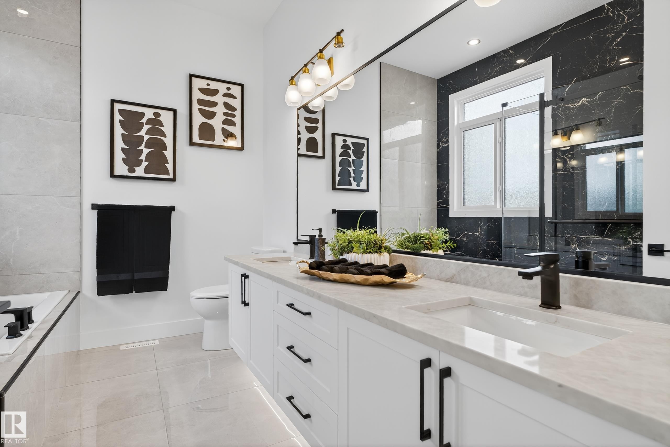 Double vanity featuring undermount sinks, stone countertops, and matte black hardware - 711 166 Avenue, Edmonton, AB - Indoor Photo Showing Bathroom
