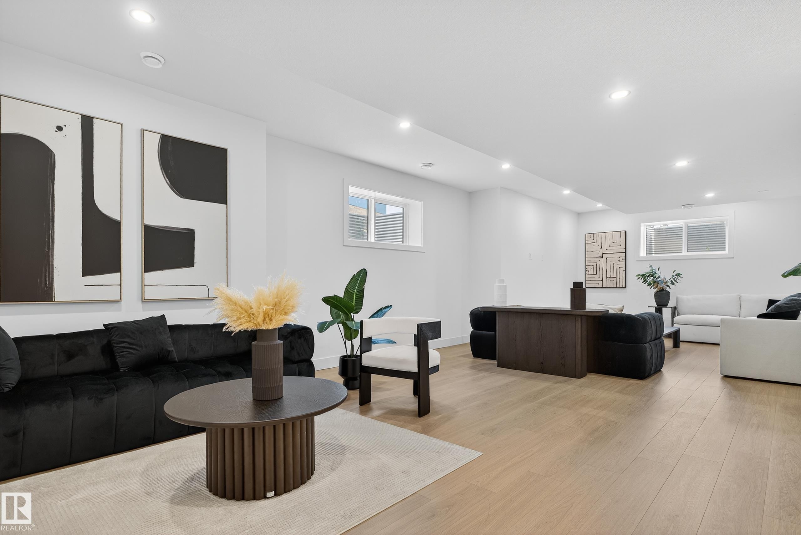 Open-concept living space featuring light wood-finish flooring, recessed lighting, and multiple windows - 711 166 Avenue, Edmonton, AB - Indoor