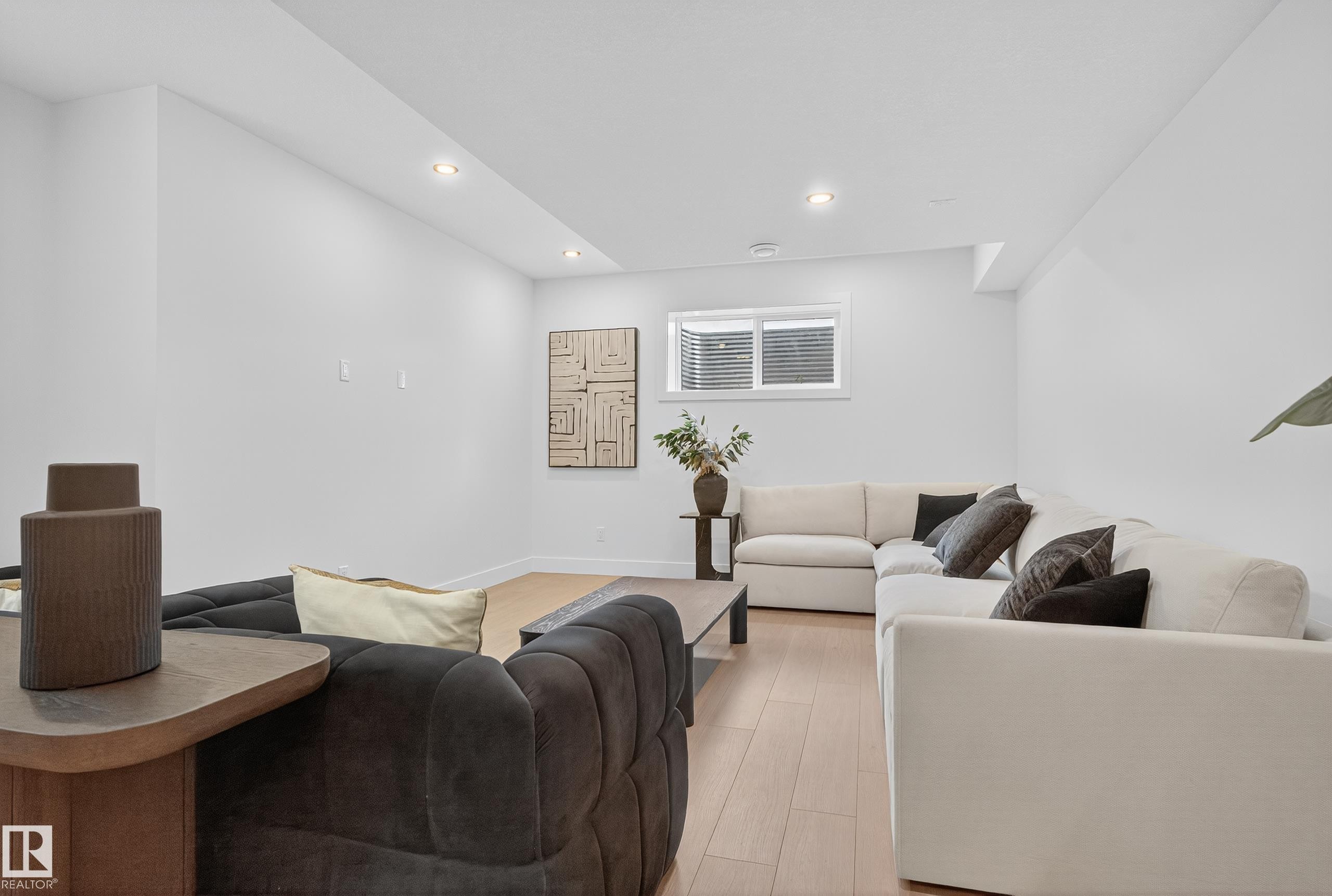 Open-concept living space featuring wood-finish flooring, recessed lighting, white walls, and a window with horizontal blinds - 711 166 Avenue, Edmonton, AB - Indoor