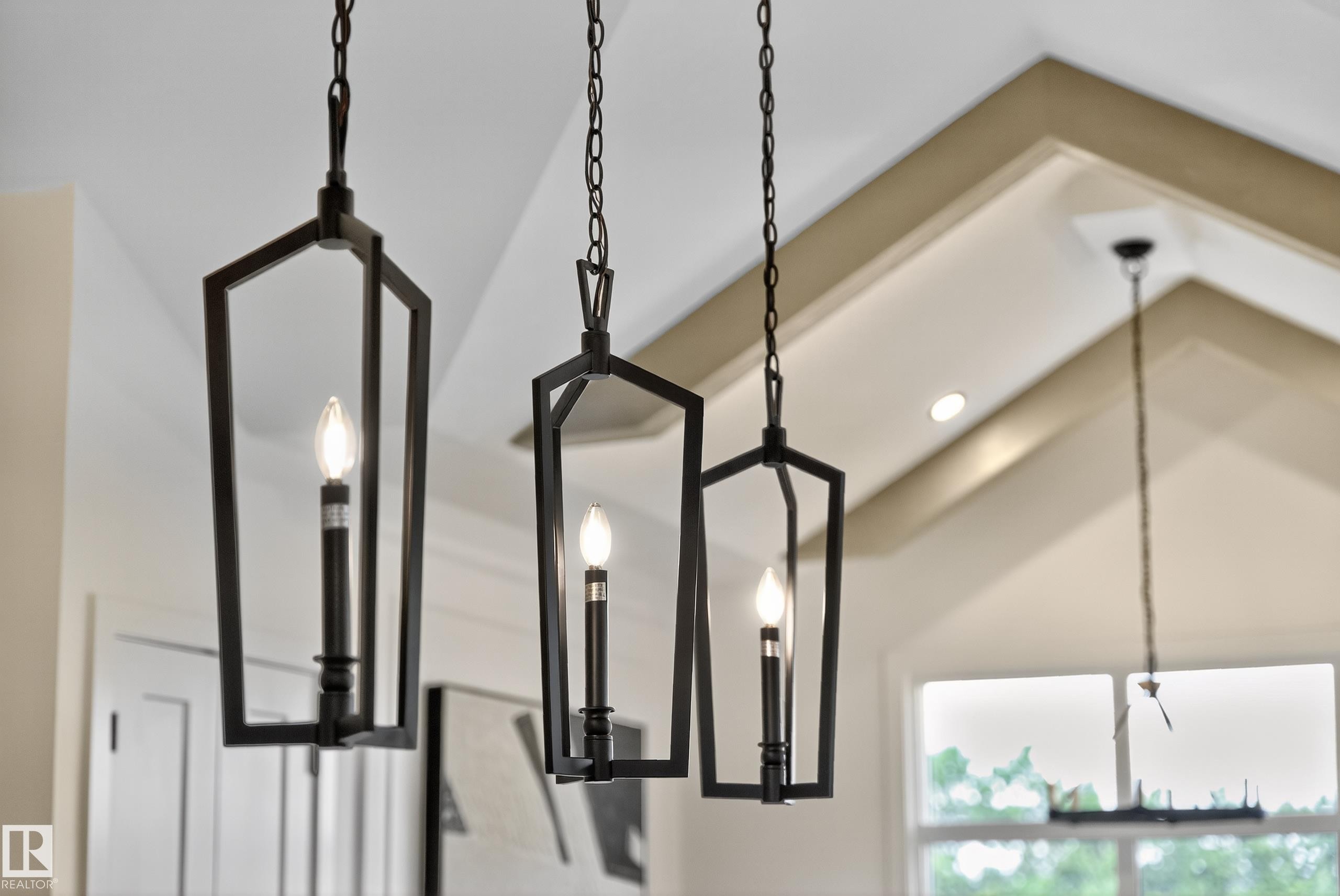 Black geometric pendant lighting fixtures with exposed candelabra bulbs - 711 166 Avenue, Edmonton, AB - Indoor Photo Showing Other Room