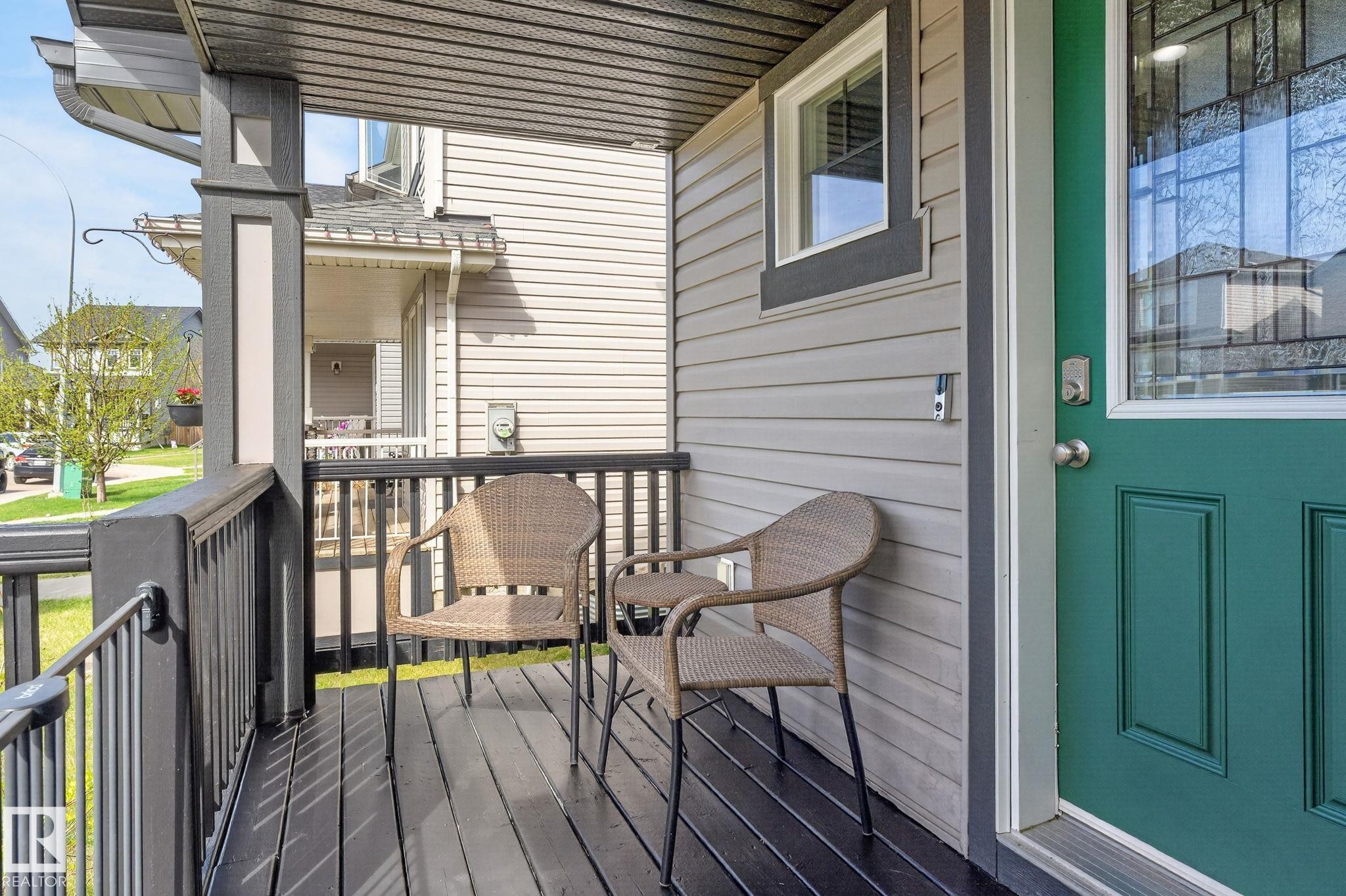 Covered front porch featuring dark wood-finish flooring and railing - 108 Hewitt Circle, Spruce Grove, AB - Outdoor With Deck Patio Veranda With Exterior