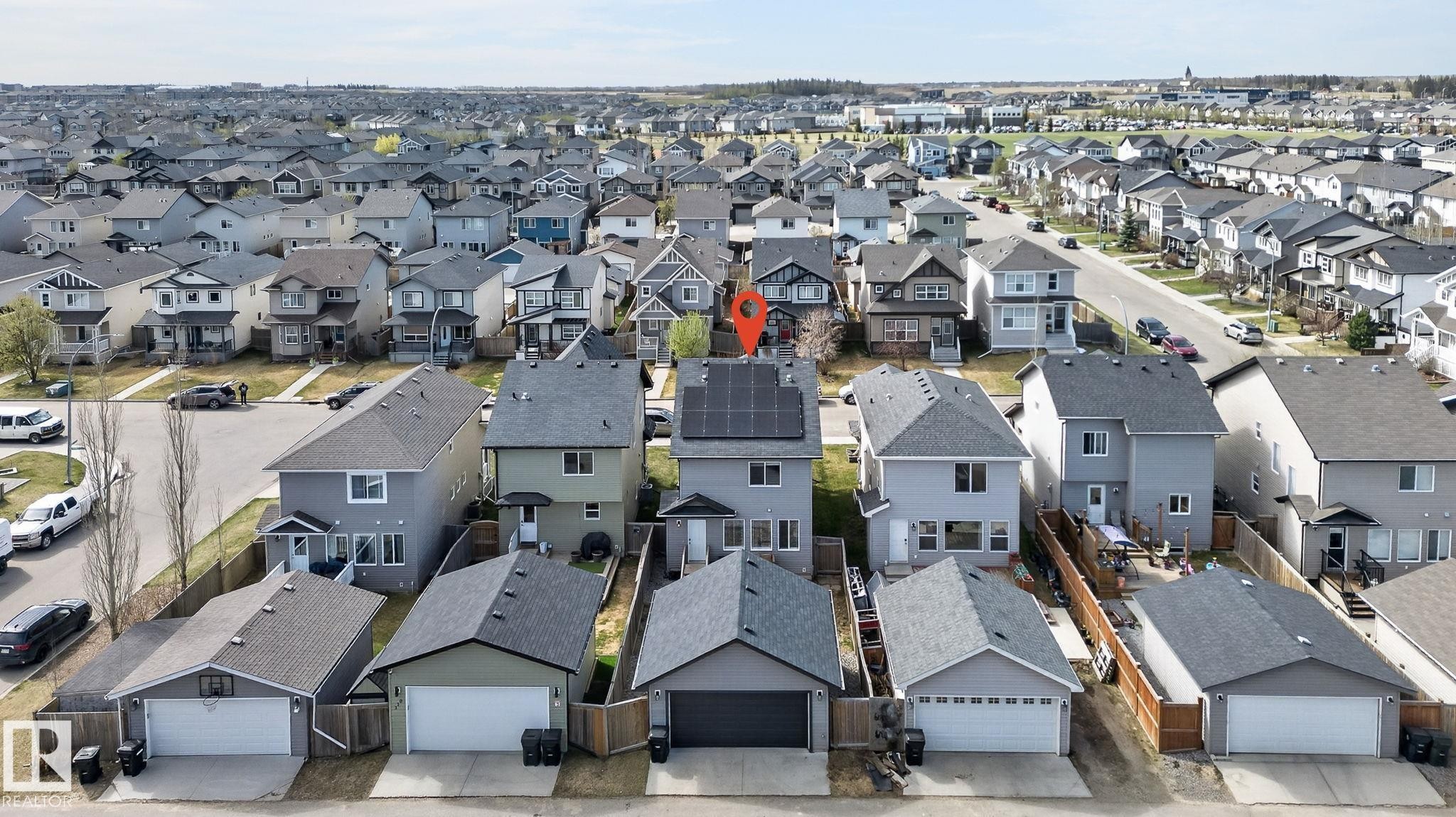 Grey two-story residence featuring a dark shingle roof with solar panels - 108 Hewitt Circle, Spruce Grove, AB - Outdoor