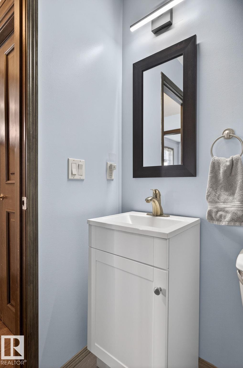 Compact bathroom vanity featuring a white cabinet, integrated sink, and gold-tone faucet - 108 Hewitt Circle, Spruce Grove, AB - Indoor Photo Showing Bathroom