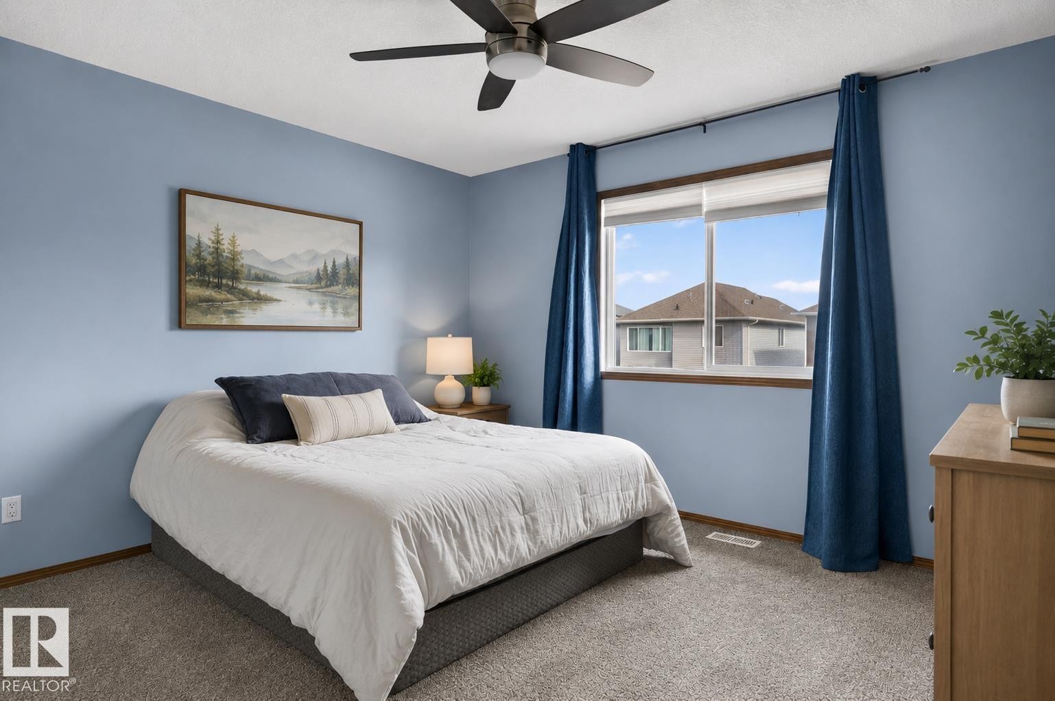 Bedroom featuring light blue walls, a ceiling fan with integrated lighting, a large window with white framing, and neutral tone carpeting - 108 Hewitt Circle, Spruce Grove, AB - Indoor Photo Showing Bedroom