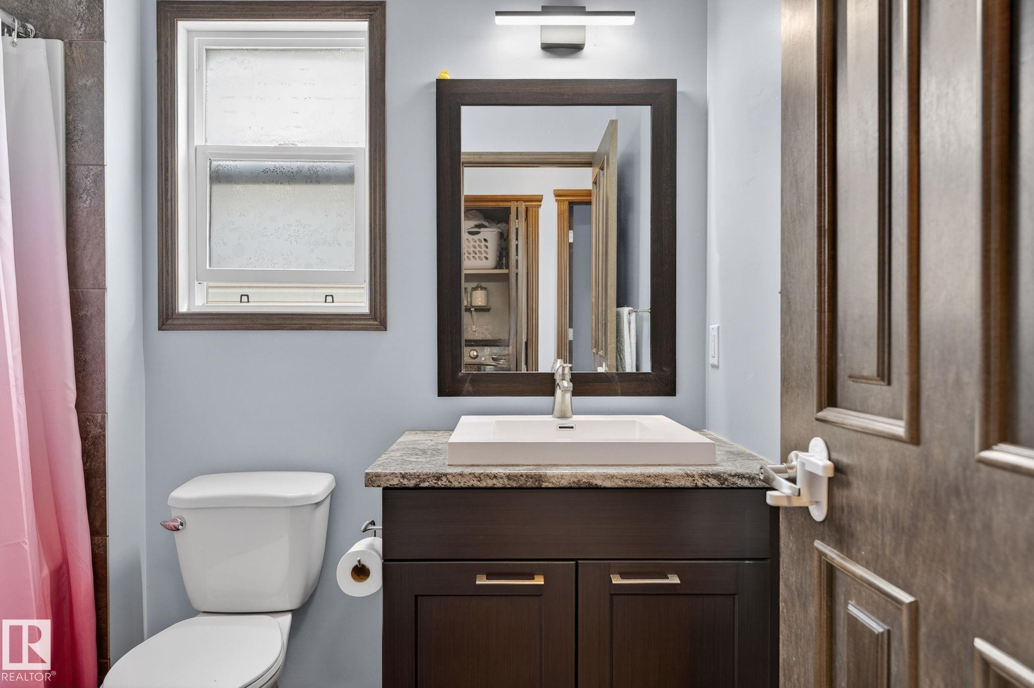 Bathroom featuring a dark wood-finish vanity with a rectangular vessel sink, stone-finish countertop, and brushed nickel faucet - 108 Hewitt Circle, Spruce Grove, AB - Indoor Photo Showing Bathroom