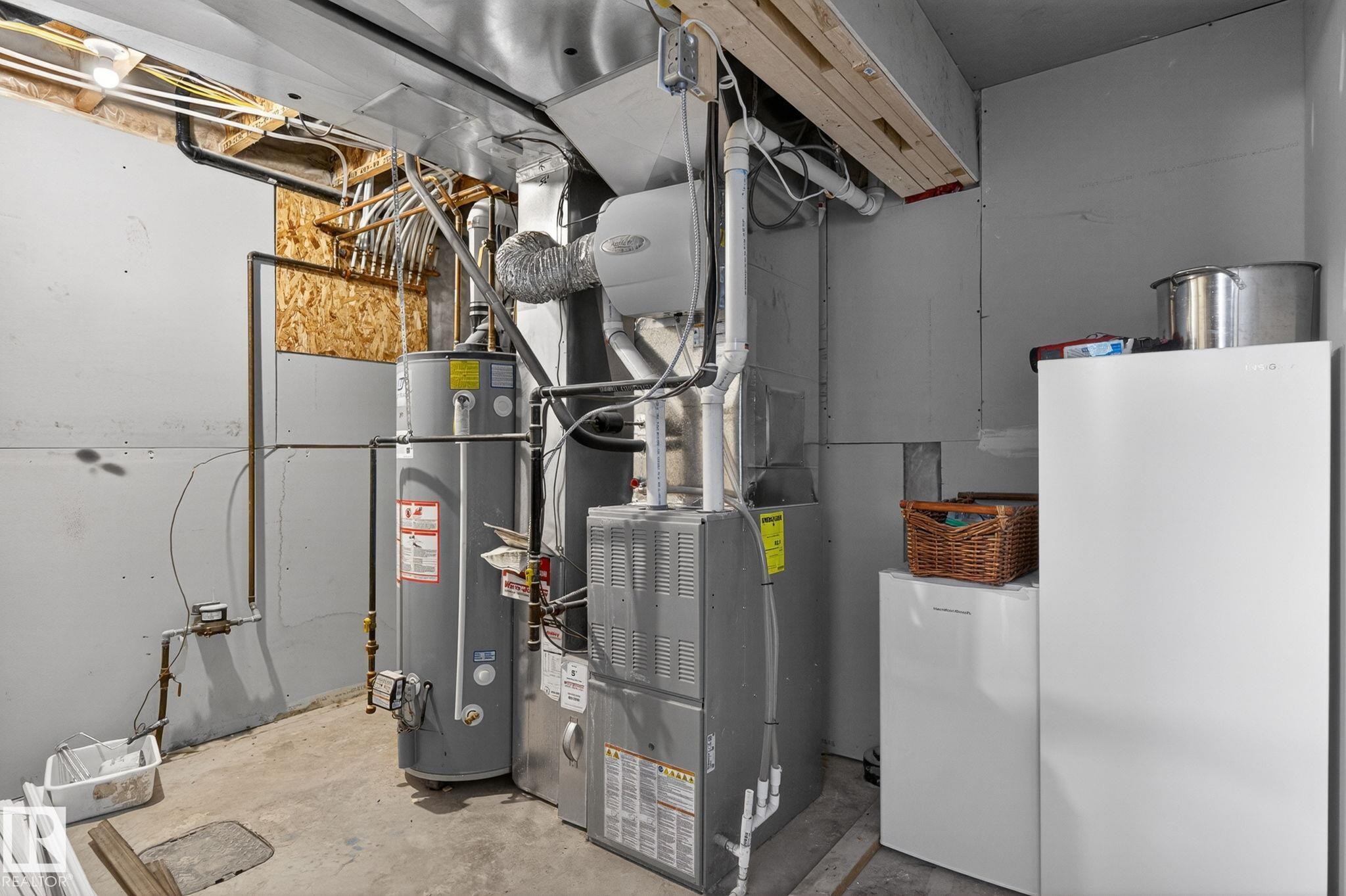 Utility area featuring a water heater, furnace, and exposed ceiling joists - 108 Hewitt Circle, Spruce Grove, AB - Indoor Photo Showing Basement