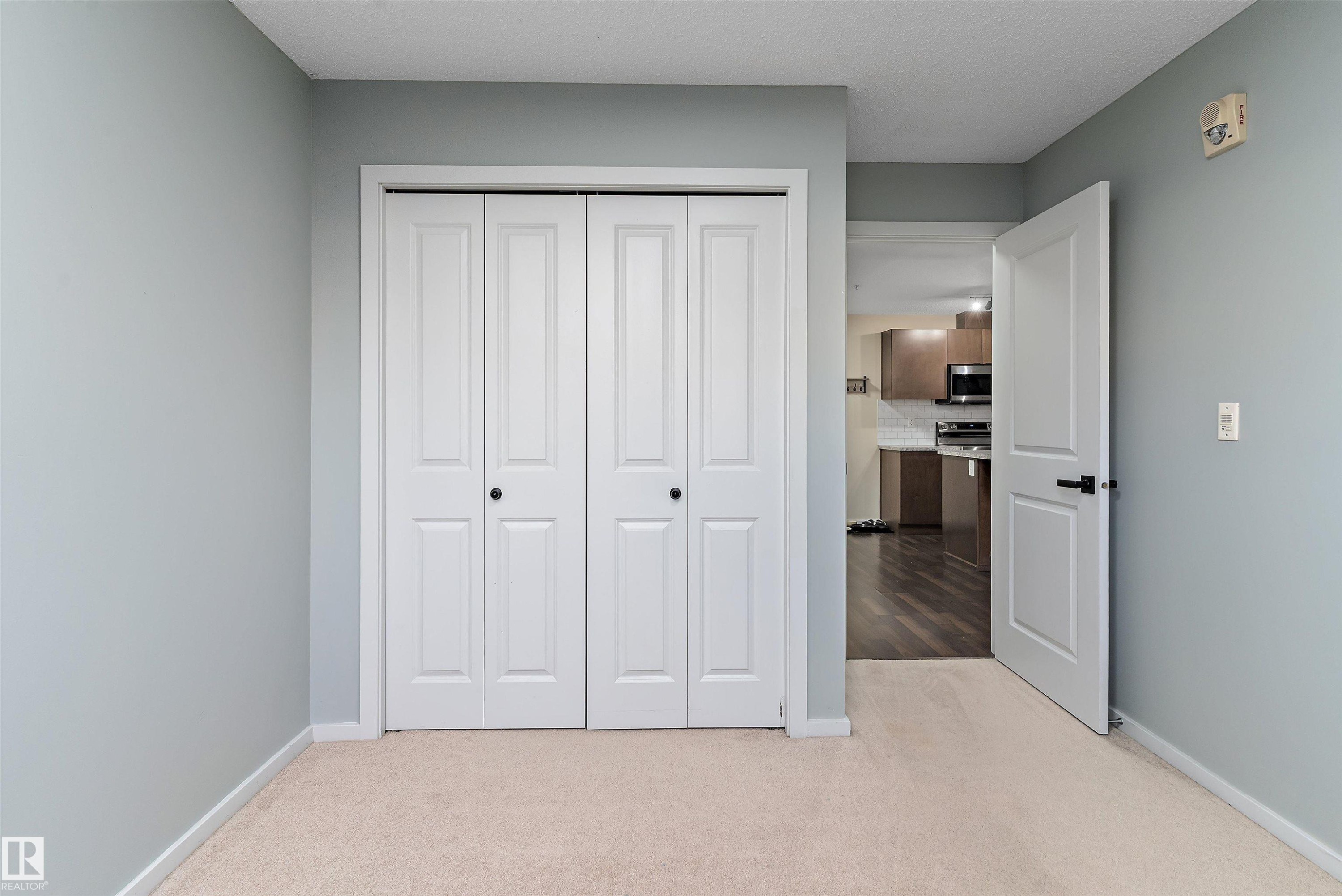 Wall-to-wall carpeting in a neutral tone, complemented by light grey wall paint - 122 3357 16A Avenue, Edmonton, AB - Indoor