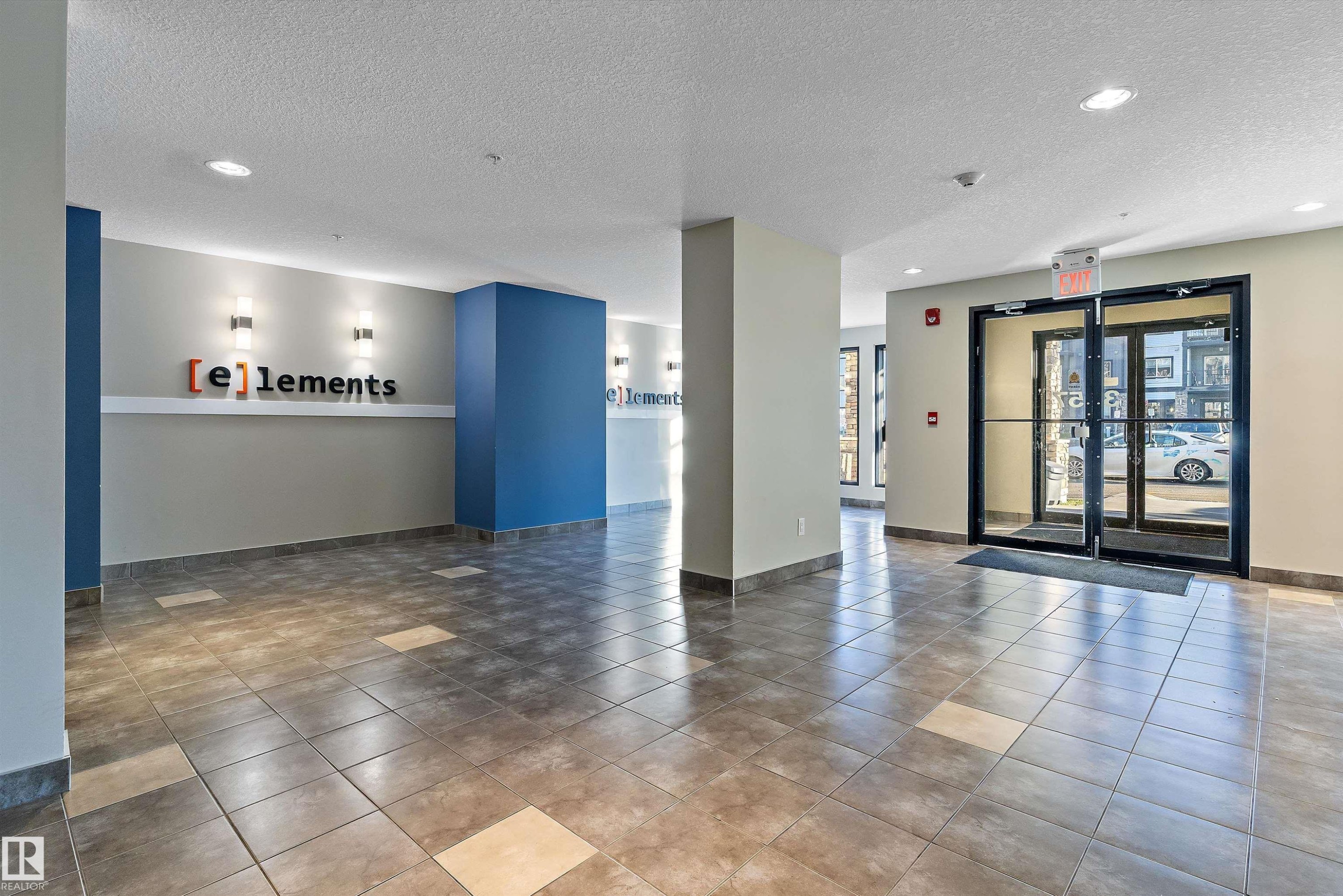 Spacious entry foyer featuring large format tile flooring with contrasting accent tiles - 122 3357 16A Avenue, Edmonton, AB - Indoor Photo Showing Other Room