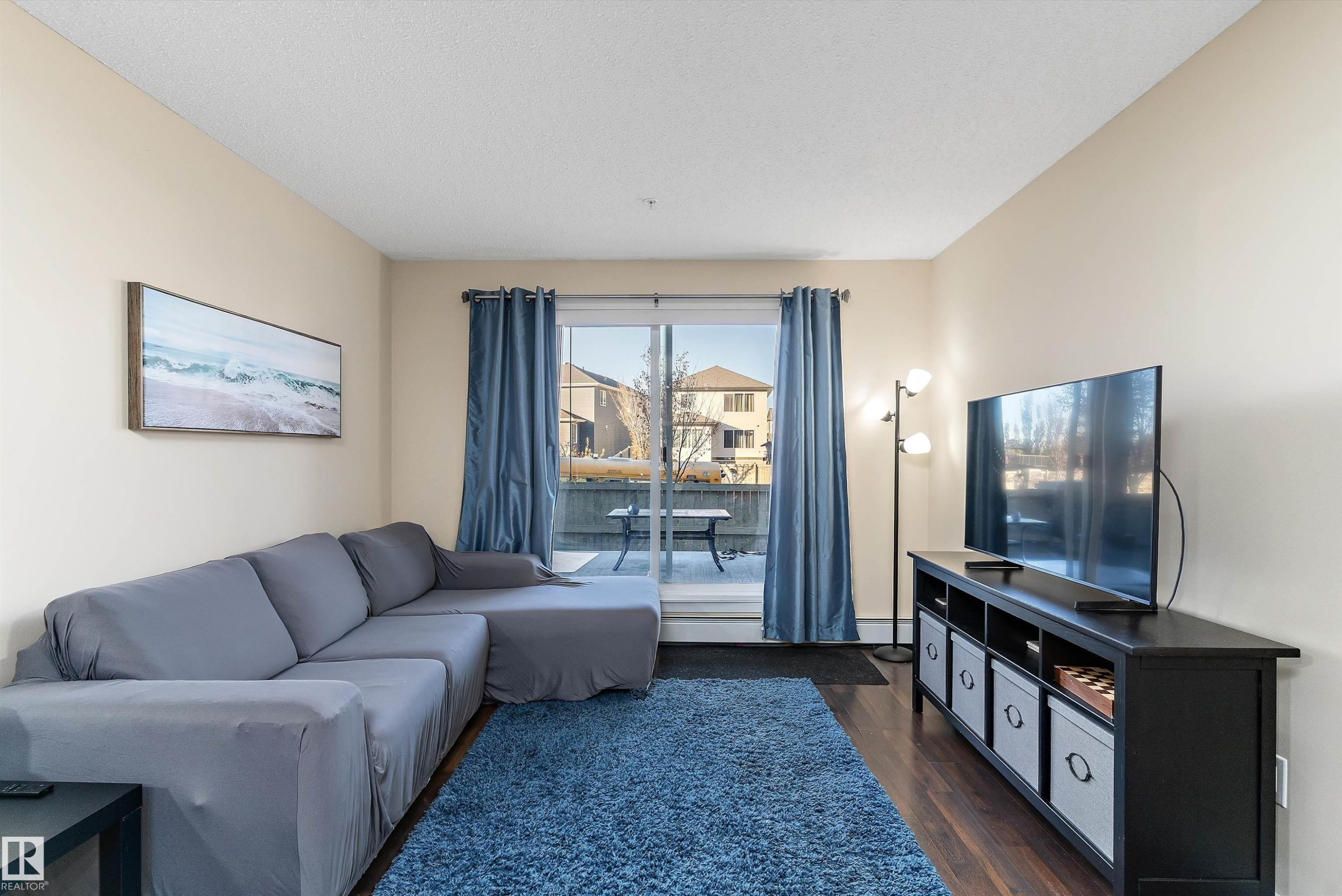Living area featuring wood-finish flooring and light-toned walls - 122 3357 16A Avenue, Edmonton, AB - Indoor Photo Showing Living Room