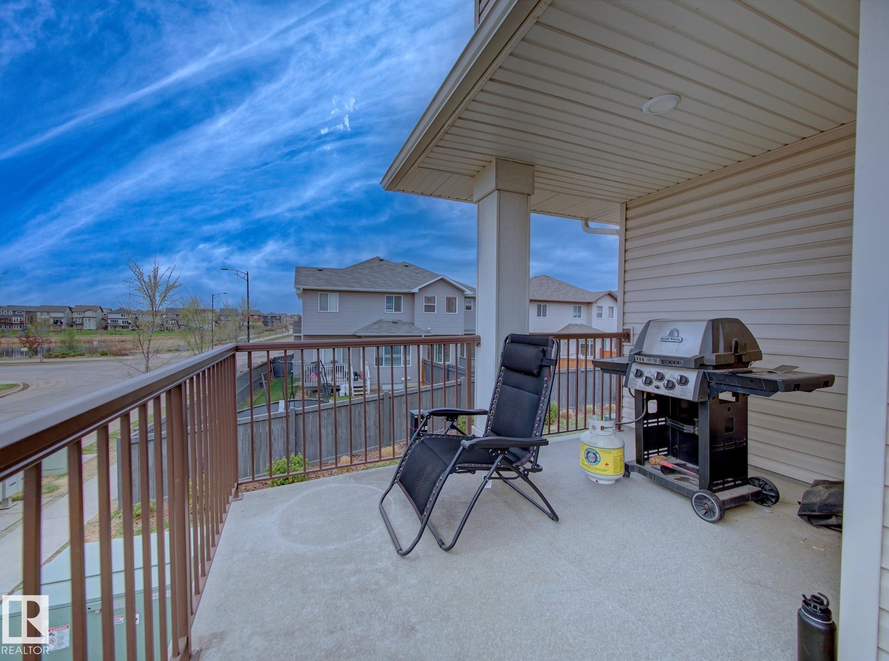 Private balcony featuring a concrete surface, protective railing, column support, and overhead soffit with recessed lighting - 11 165 Cy Becker Boulevard, Edmonton, AB - Outdoor With Deck Patio Veranda With Exterior