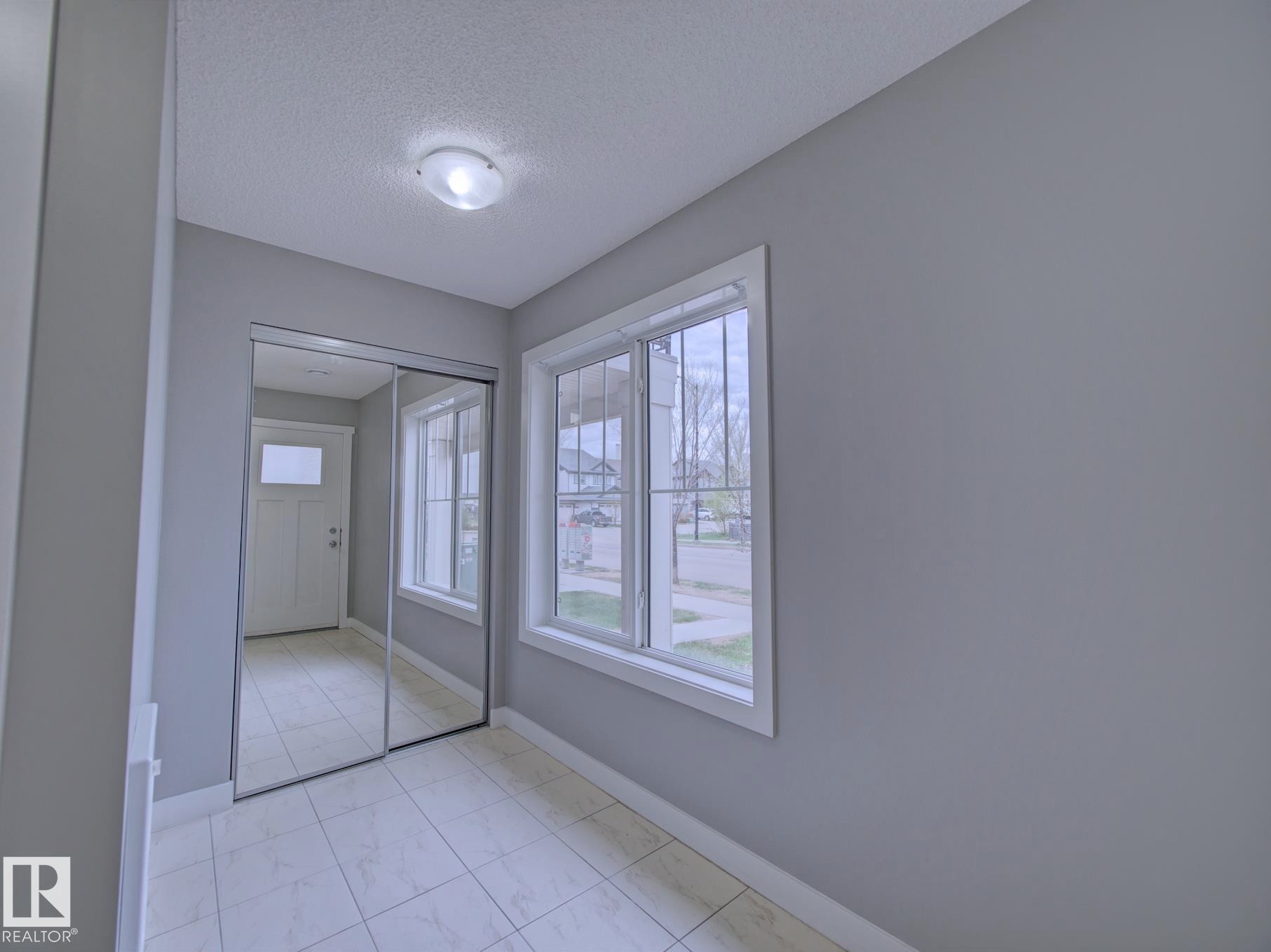 Foyer featuring light gray walls and tiled flooring - 11 165 Cy Becker Boulevard, Edmonton, AB - Indoor Photo Showing Other Room