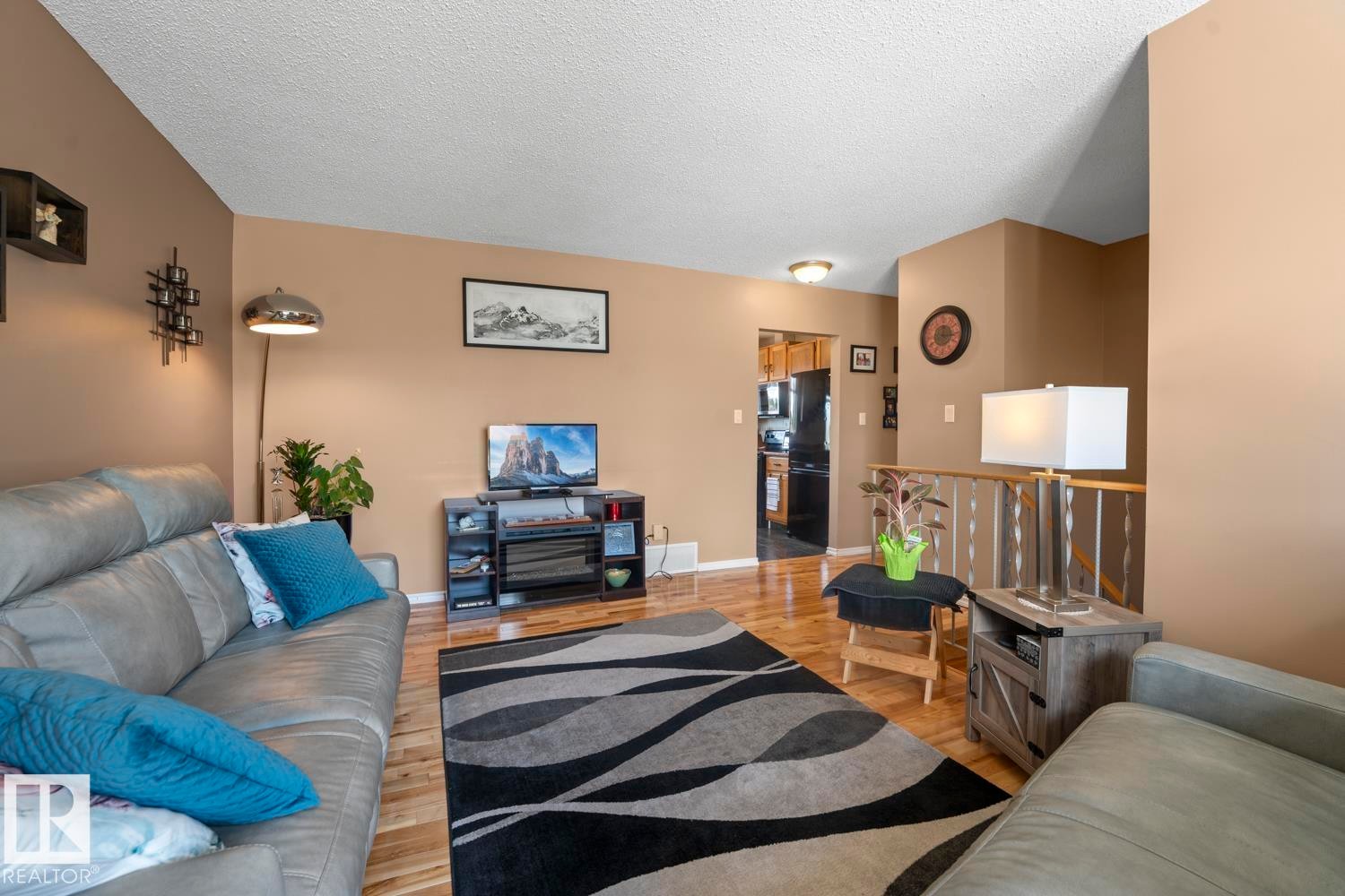 Living area featuring wood-finish flooring, neutral wall tones, and a ceiling-mounted light fixture - 1304 12 Street, Cold Lake, AB - Indoor Photo Showing Living Room