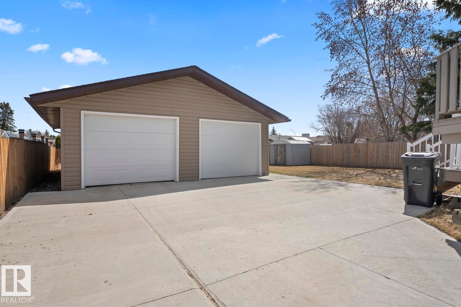 Detached two-car garage with tan siding and white garage doors - 1304 12 Street, Cold Lake, AB - Outdoor With Exterior