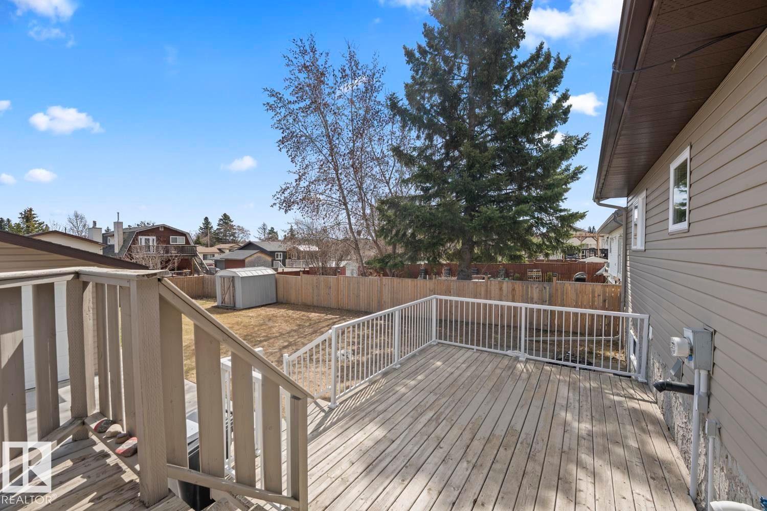 Expansive rear deck featuring wood-finish flooring and white railings - 1304 12 Street, Cold Lake, AB - Outdoor With Exterior