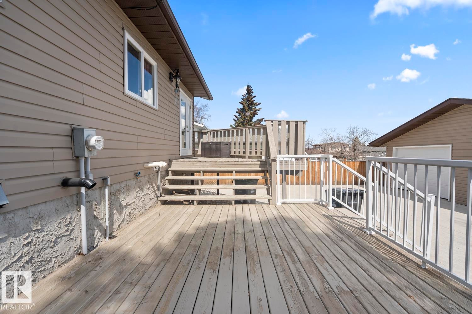 Expansive wood deck with white metal railings, offering multi-level access to the property - 1304 12 Street, Cold Lake, AB - Outdoor With Deck Patio Veranda With Exterior