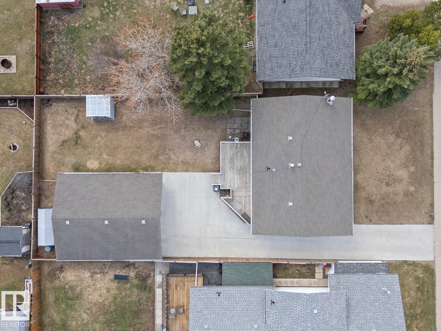 Property featuring a main residence with a gray shingle roof, an attached garage with a matching shingle roof, and a large paved driveway - 1304 12 Street, Cold Lake, AB - Outdoor