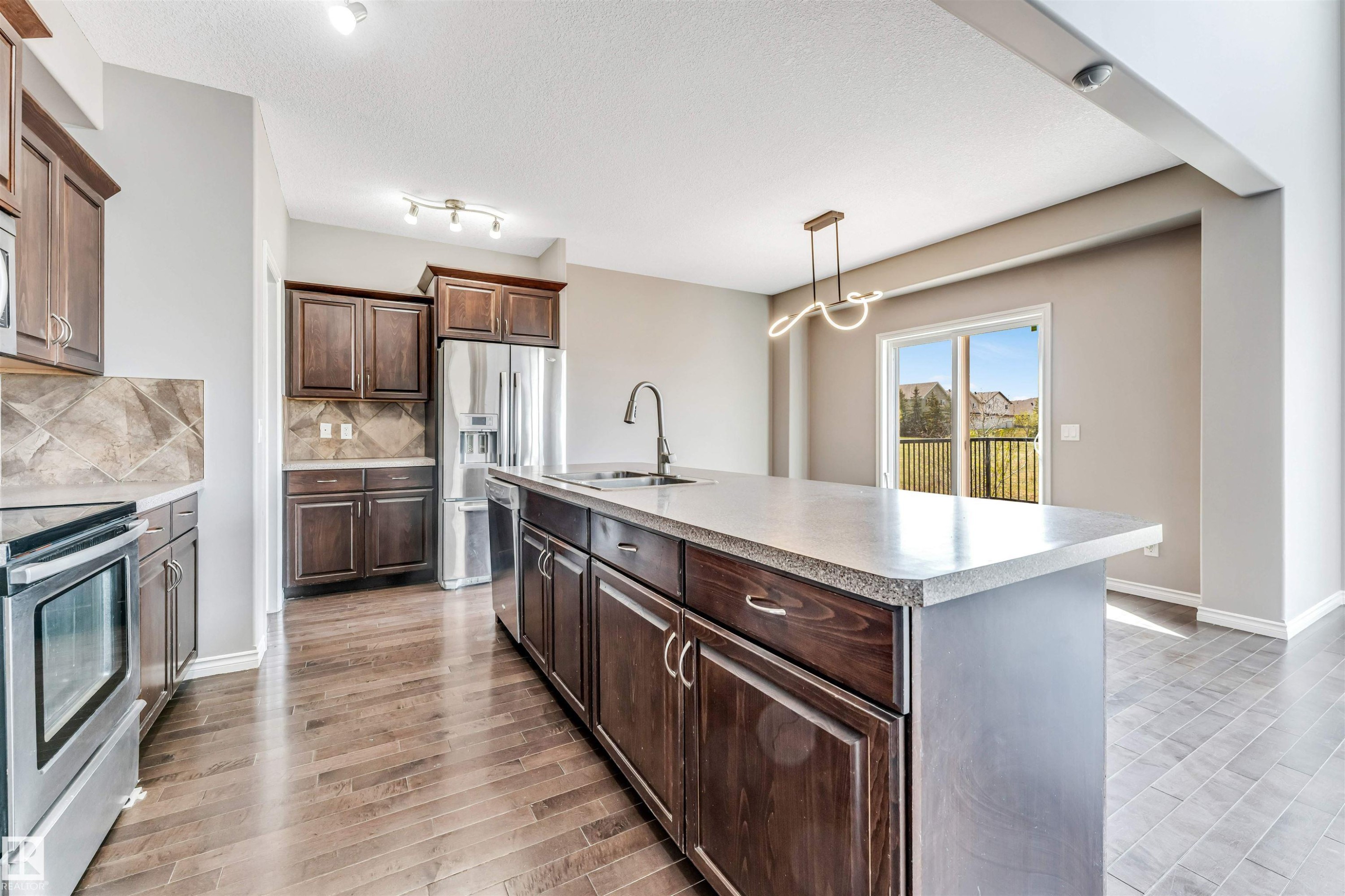 Kitchen featuring a central island with an undermount sink and a gooseneck faucet - 2138 32B Street, Edmonton, AB - Indoor Photo Showing Kitchen With Stainless Steel Kitchen With Upgraded Kitchen